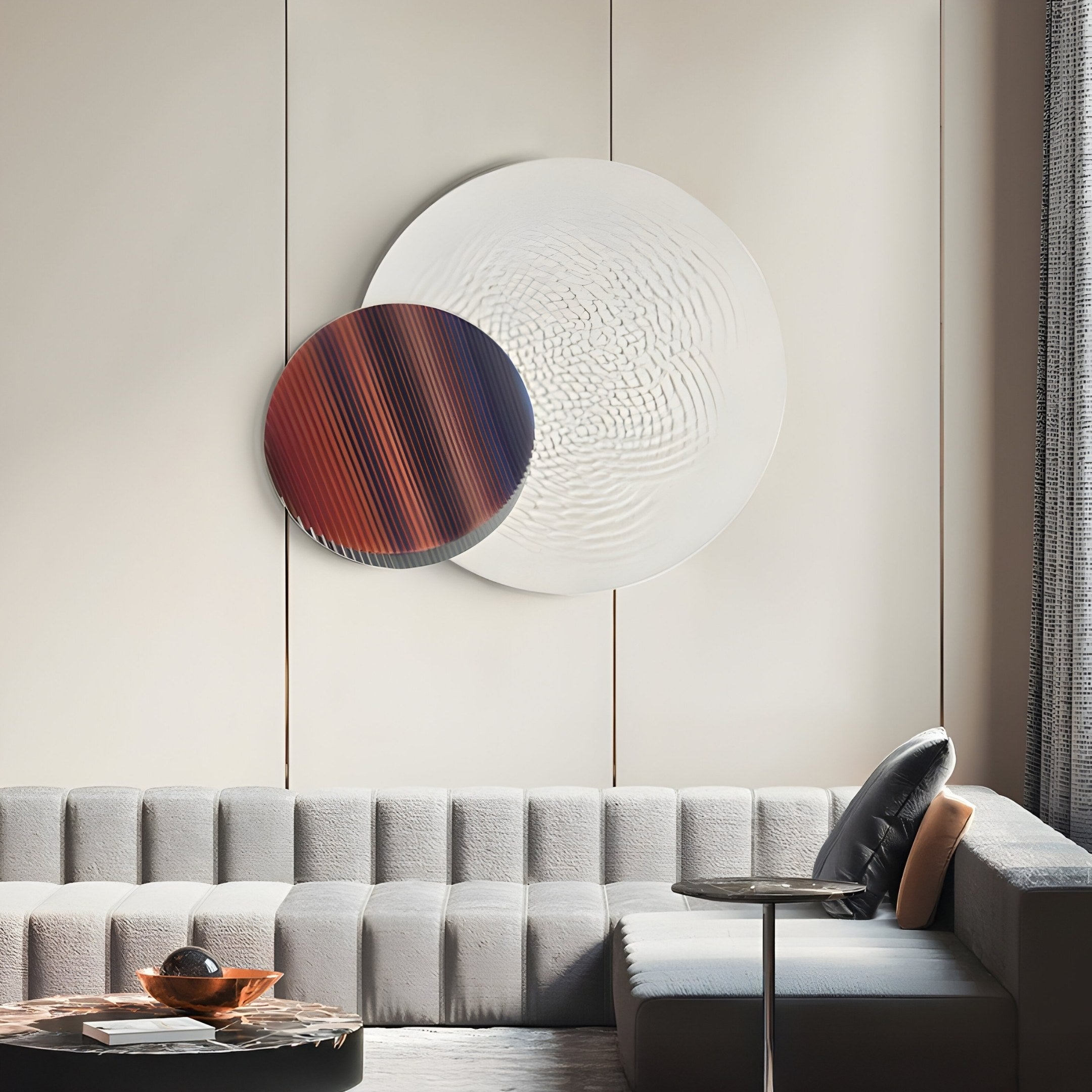 A modern living room showcases a light gray tufted sectional sofa. Above, the Lucentis White & Earthy Gradient Wood Relief 3D Wall Art by Giant Sculptures adds interest with its red and white textured circles. Nearby, a small side table with a pillow displays a wooden bowl, enhancing the elegant space.