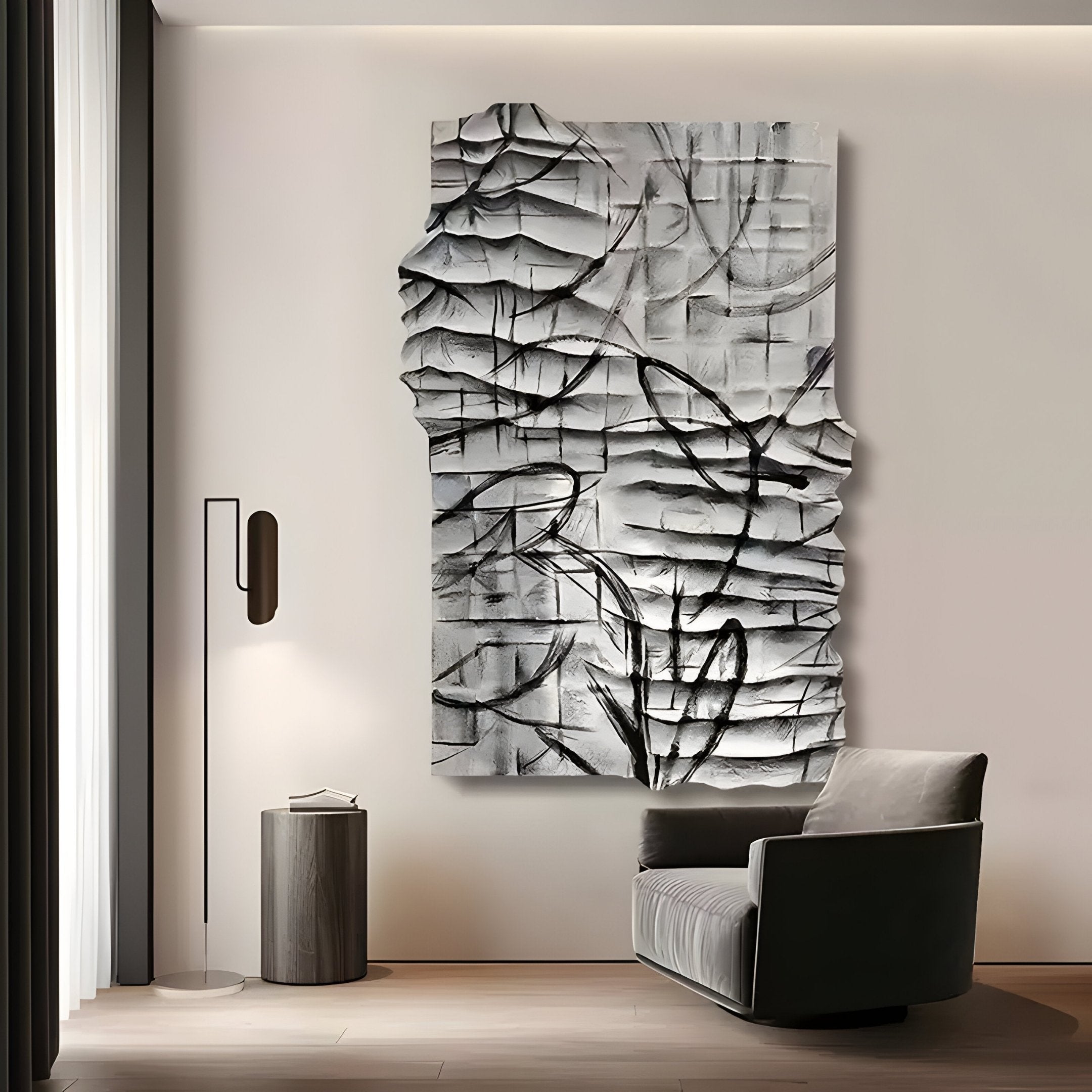 A modern, minimalist room showcases the Calidora Abstract Contour Textured 3D Relief Wall Art by Giant Sculptures, with fluid lines and folds. A gray armchair pairs with a cylindrical side table on wooden flooring. Natural light enhances the serene ambiance while the wall art adds depth.