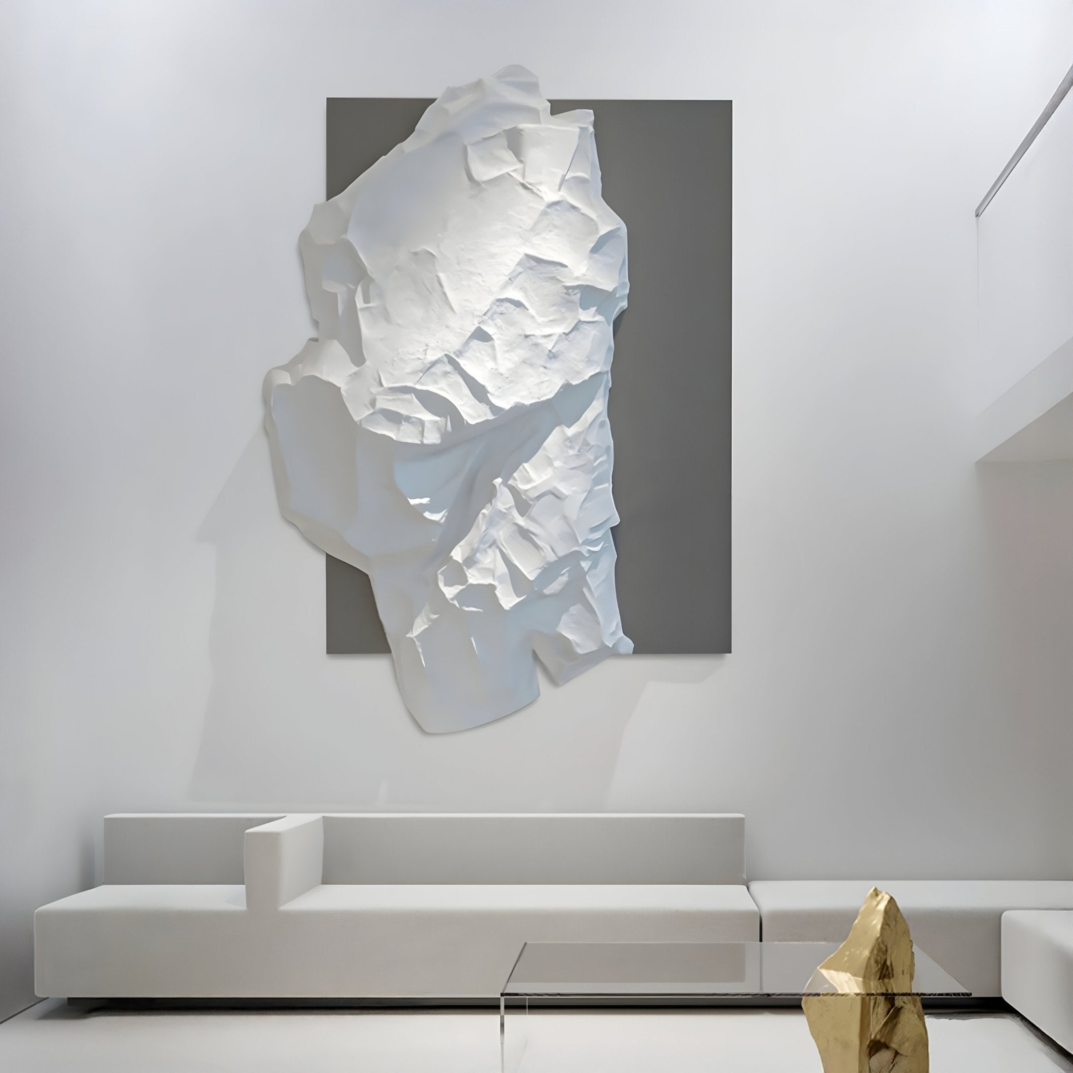 A minimalist living room features the Veritas White & Silver Abstract Wood Relief 3D Wall Art by Giant Sculptures on a dark square background. Below, sleek white modular seating and a glass coffee table enhance the space, complemented by geometric gold decor pieces.
