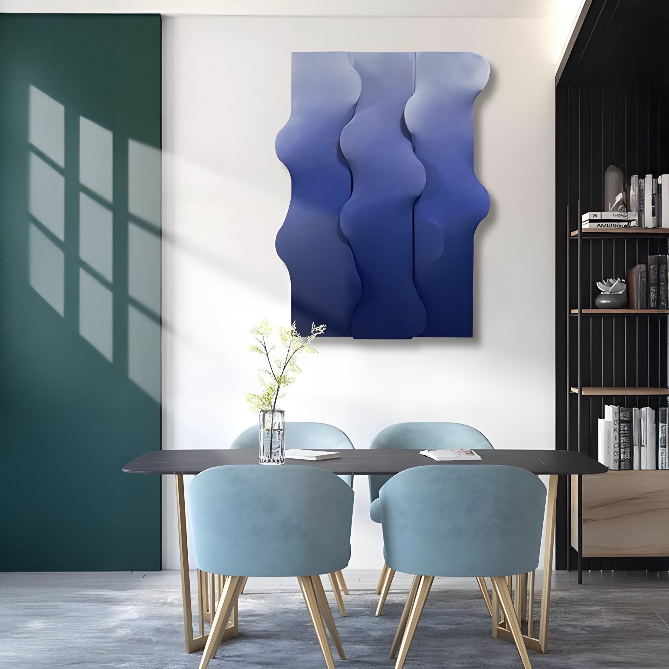 A modern dining area showcases Mystique Blue Fabric chairs around a dark table with white flowers. Giant Sculptures Mystique Blue Fabric Abstract Wood Relief 3D Wall Art adorns the wall, casting window patterns nearby. A bookshelf is partially visible to the right.