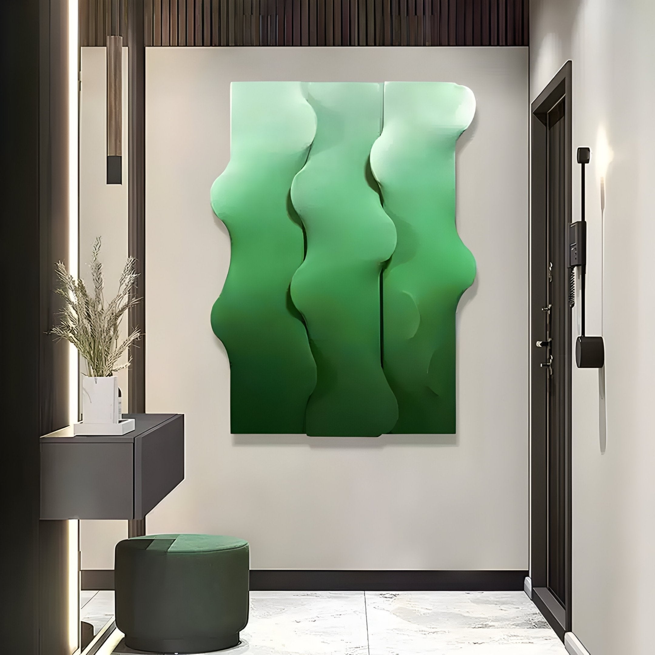 A modern hallway features Giant Sculptures Mystique Green Fabric Abstract Wood Relief 3D Wall Art with wavy patterns. Below, a grey console holds a plant in a white pot, while a round green ottoman sits elegantly on the light marble floor, enhancing the serene space.