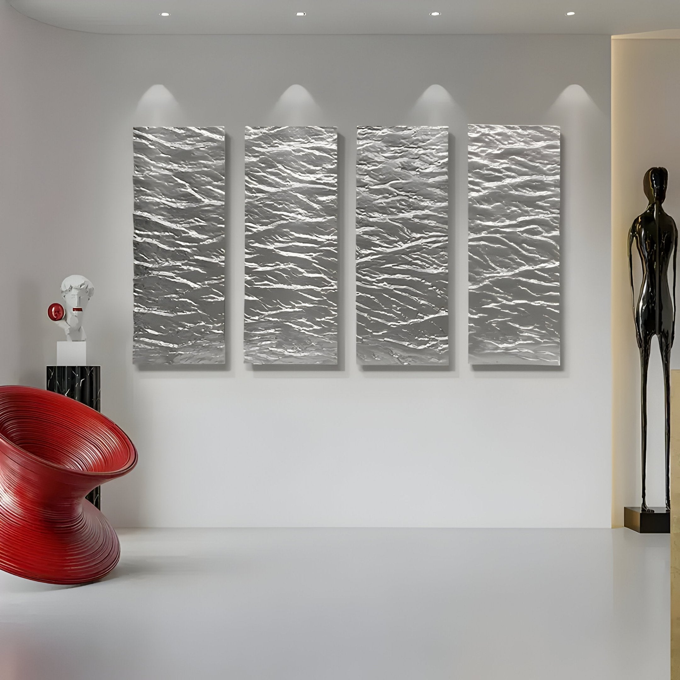 A modern room features four textured wall panels and a tall black figure from Giant Sculptures, paired with a red spiral chair. The Illume 4-Panel Silver Hand-Painted Wood Relief 3D Wall Art adds depth to the white backdrop, and spotlights beautifully highlight the 3D elements.
