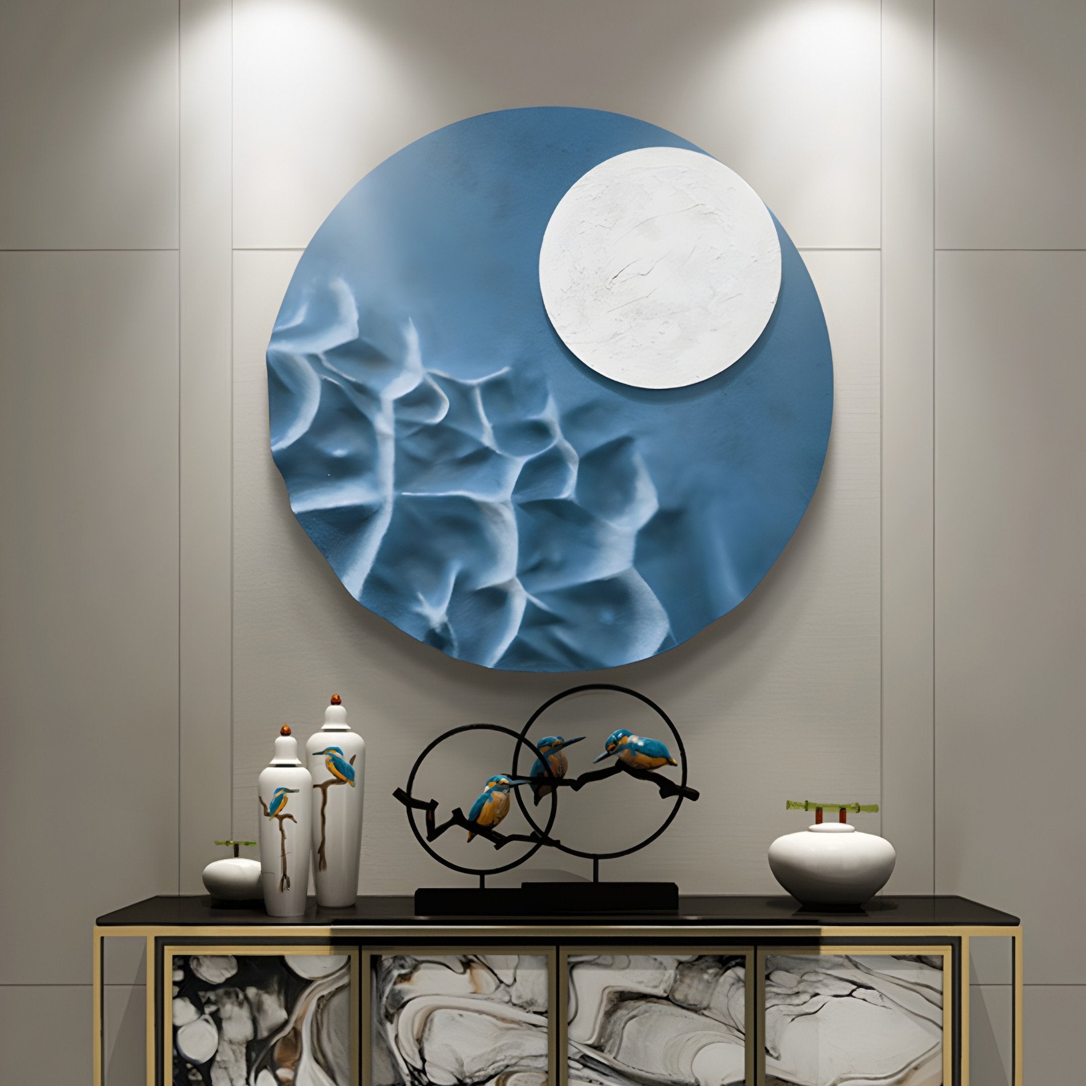 The Verve Soft Blue Wood Relief 3D Wall Art by Giant Sculptures hangs above a decorative table displaying vases and a birds-on-rings sculpture. Below, the cabinet flaunts a marbled pattern, highlighted elegantly by overhead lights.