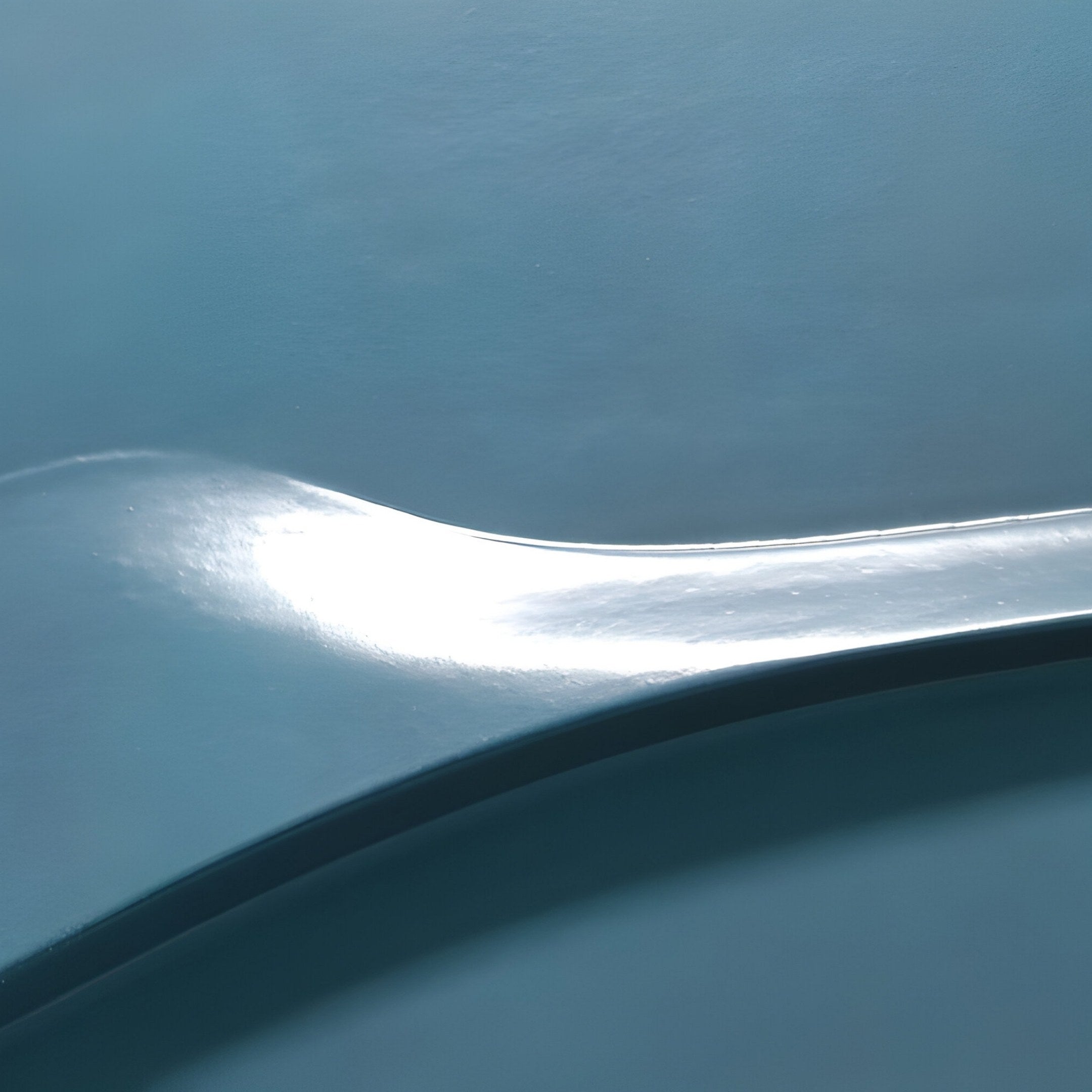 The Velar Horizontal Blue Wood Carving 3D Wall Art by Giant Sculptures showcases a smooth, curved surface with a glossy finish, reflecting light. It features varying shades of blue in an elegant wave motif for a sleek, modern look.