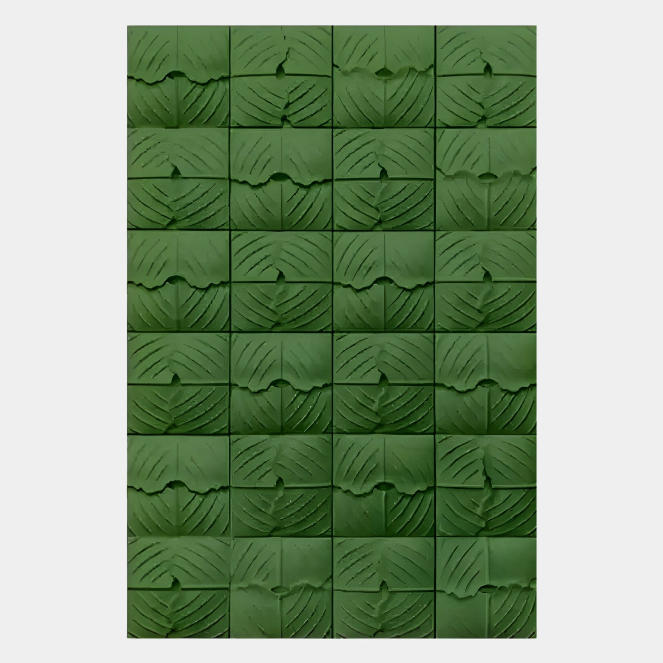 The Vellura Green Textured Wood Relief 3D Wall Art by Giant Sculptures features 25 hand-carved green wooden tiles with curved and diagonal engravings, forming a leaf-like abstract pattern on a light background.