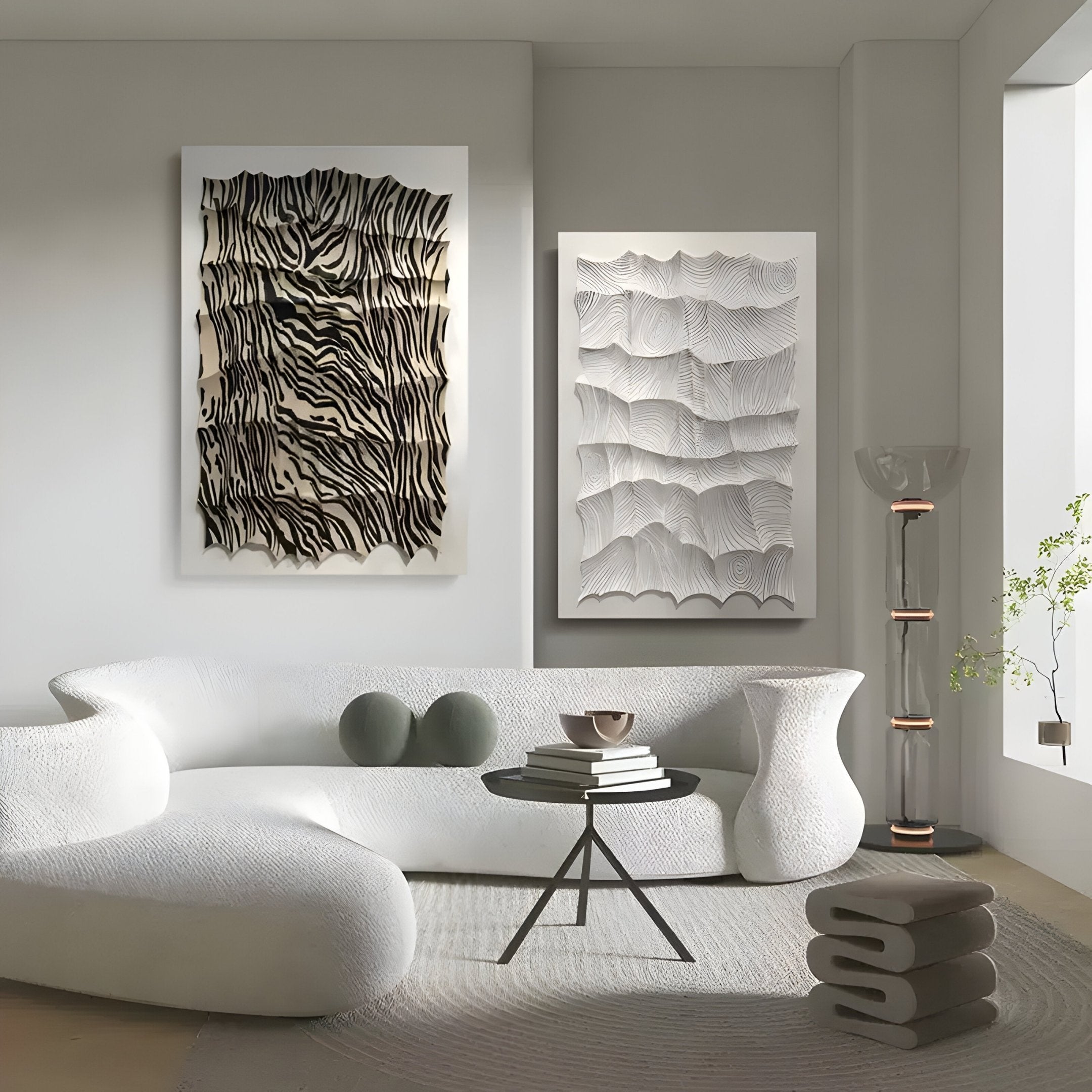 A modern, minimalist living room featuring white sculptural furniture, a round rug, a glass lamp, books on a small round table, a potted plant by the window, and Giant Sculptures’ Novara White II Hand-Painted Wood Relief 3D Wall Art.