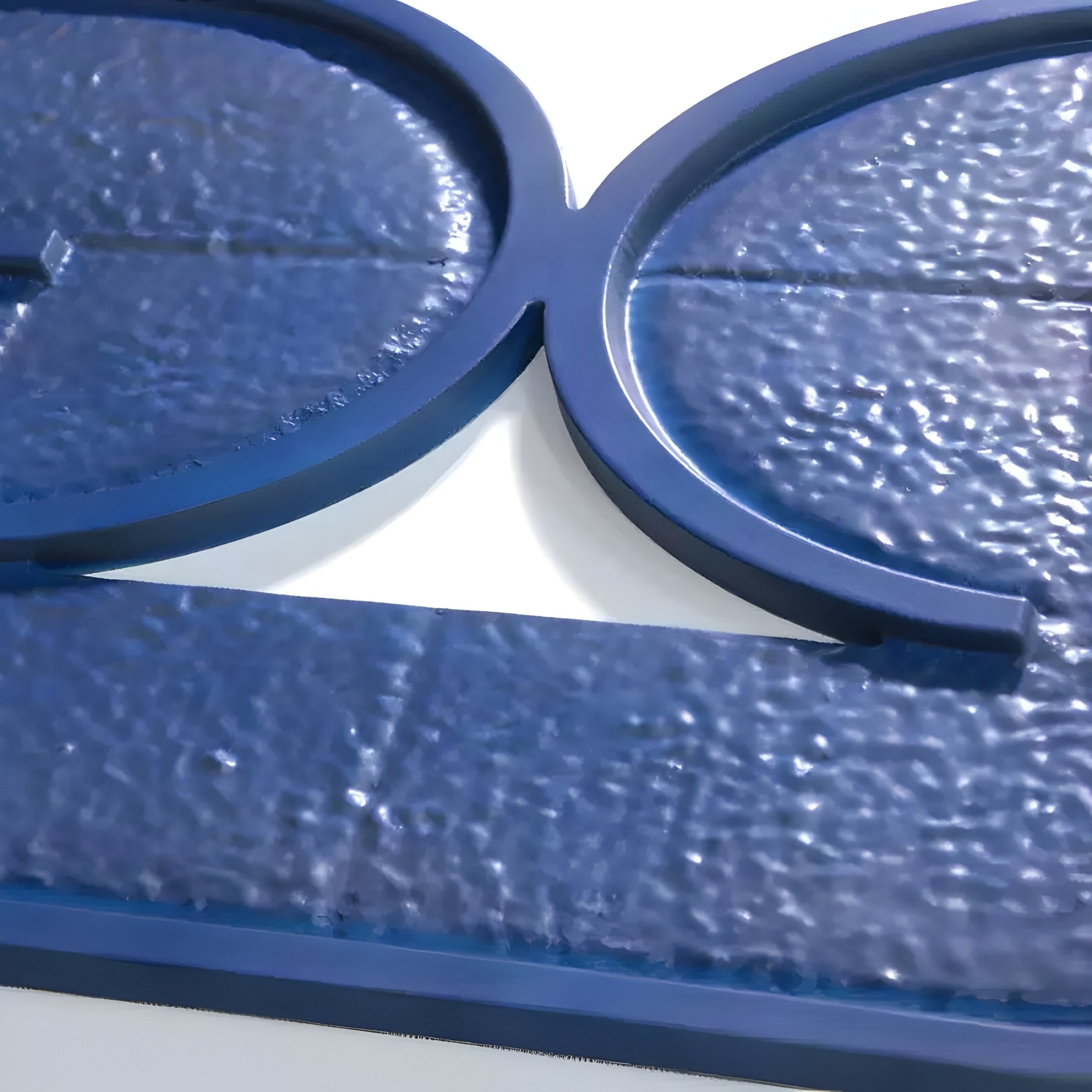 Infinique Horizontal Blue Abstract Wood Carving 3D Wall Art by Giant Sculptures features a textured blue surface with intersecting raised circular shapes, offering a soft, slightly reflective material. Its contemporary decor adds a subtle sheen that playfully catches the light.