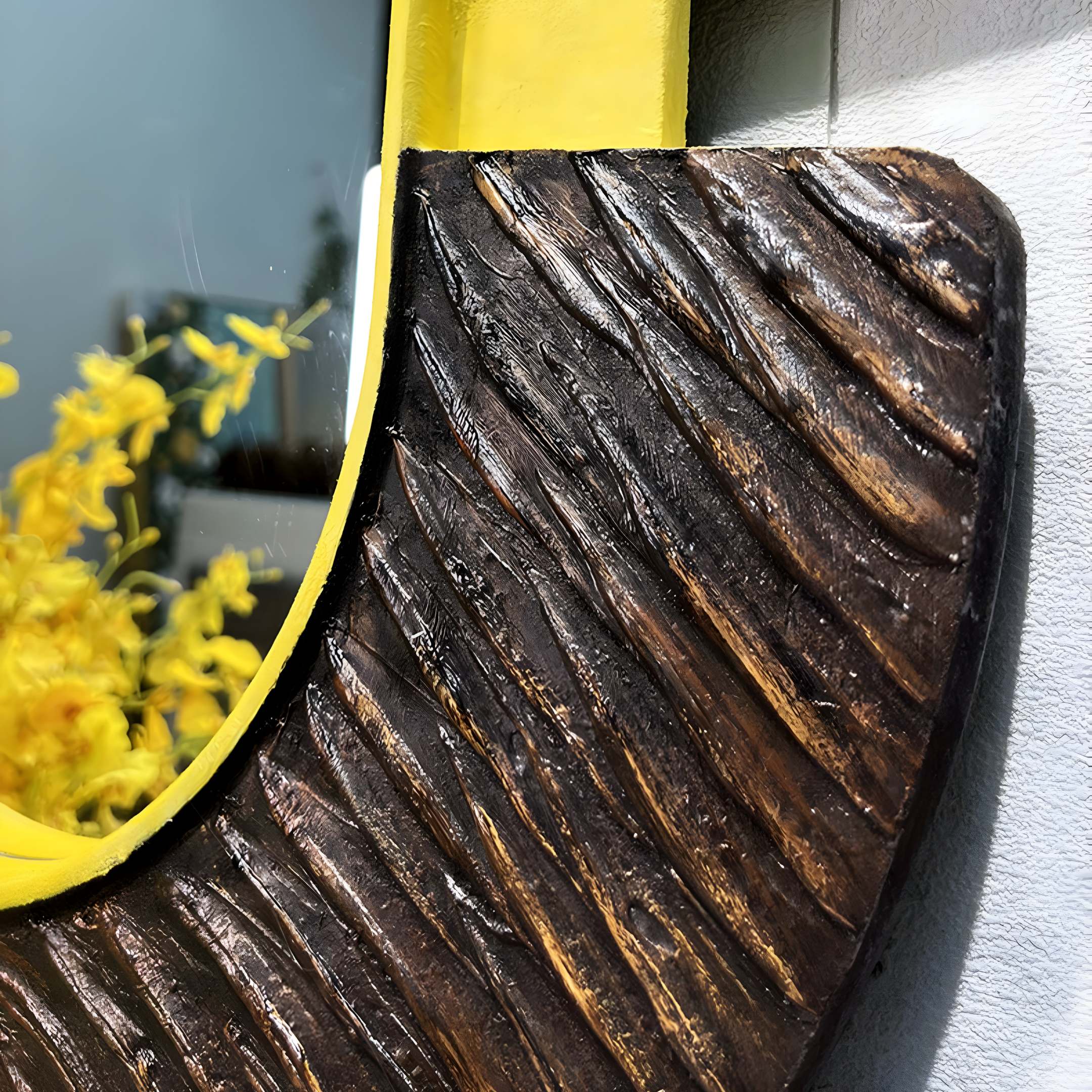 The Arcus Black & Yellow Zebra Stripes Mirror 3D Wooden Wall Art by Giant Sculptures features a textured, grooved frame. Its upper yellow section contrasts with natural wood below, beautifully reflecting yellow flowers for a colorful accent in modern home decor.