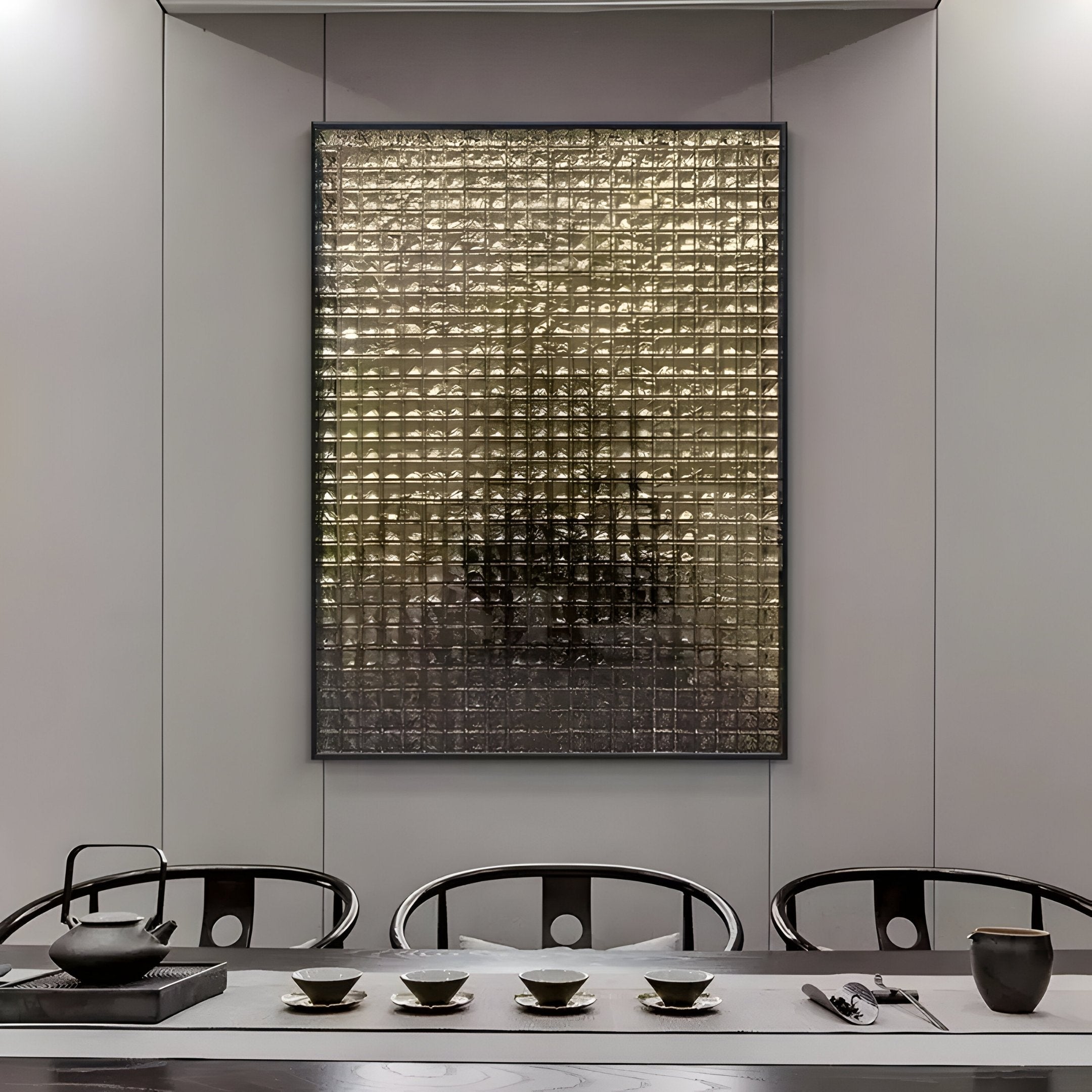 A minimalist dining room features a sleek table set with a black teapot, cups, and utensils. The wall showcases the Synova Gold I Hand-Painted Wood Relief 3D Wall Art by Giant Sculptures, adding depth and intrigue. Dark chairs complement the neutral tones for a sophisticated atmosphere.