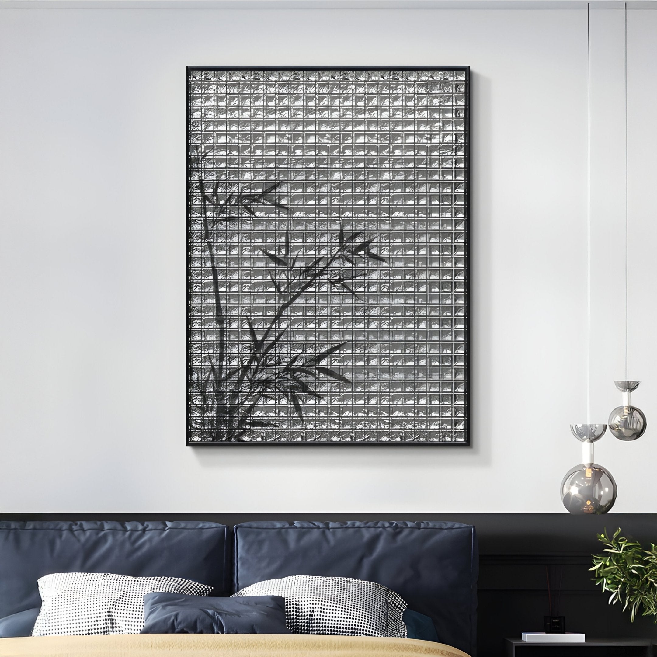 A modern bedroom features the Synova Silver I Hand-Painted Wood Relief 3D Wall Art by Giant Sculptures, showcasing a bamboo silhouette on a metallic gray background. Below is a bed with dark blue pillows, a beige blanket, and two glass pendant lights on the right.