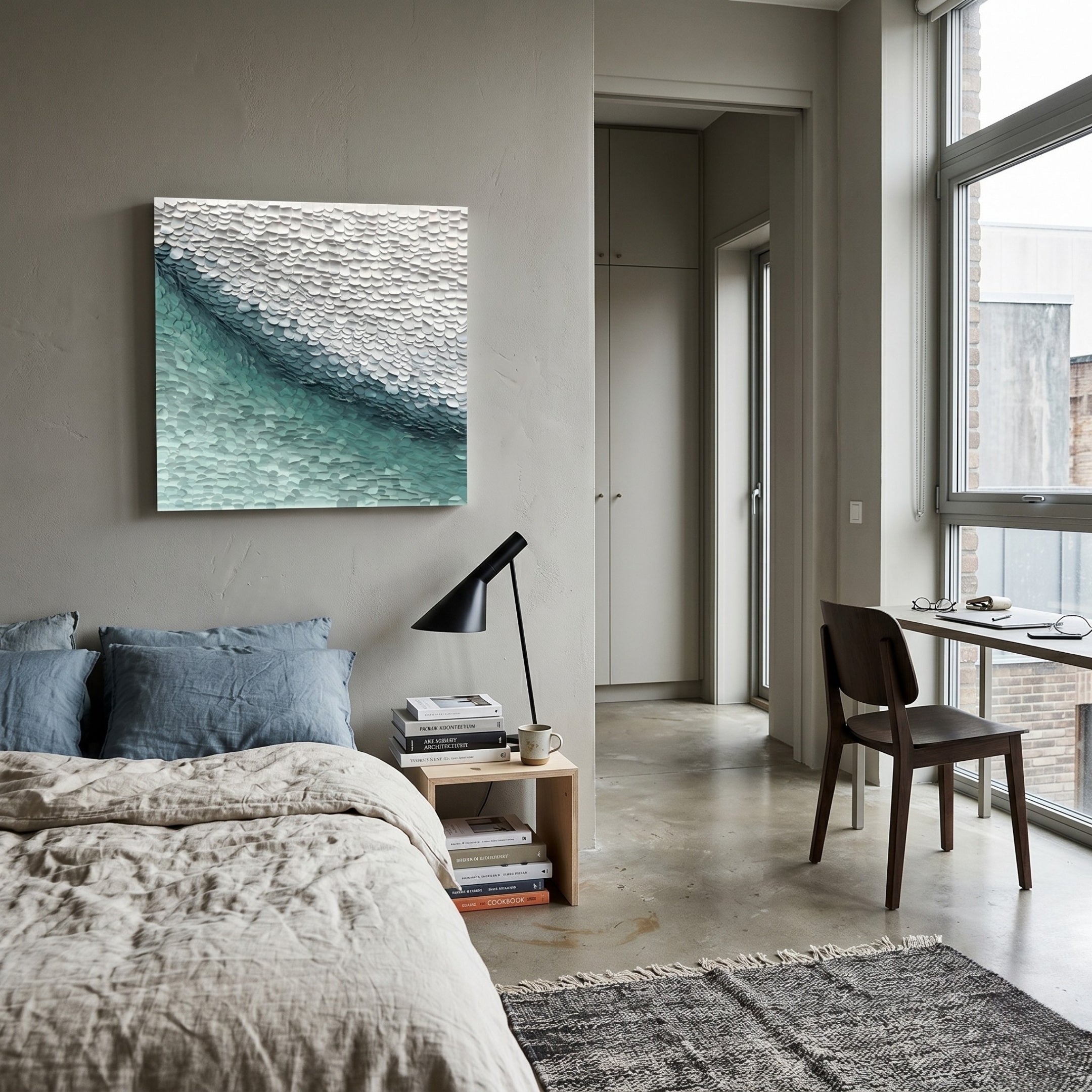 A modern, minimal bedroom with a neatly made bed, a wooden nightstand with books and a lamp, Giant Sculptures’ Seravelle Mist Blue Gradient Layered 3D Paper Wall Art above the bed, a desk and chair by large windows, and abundant natural light.