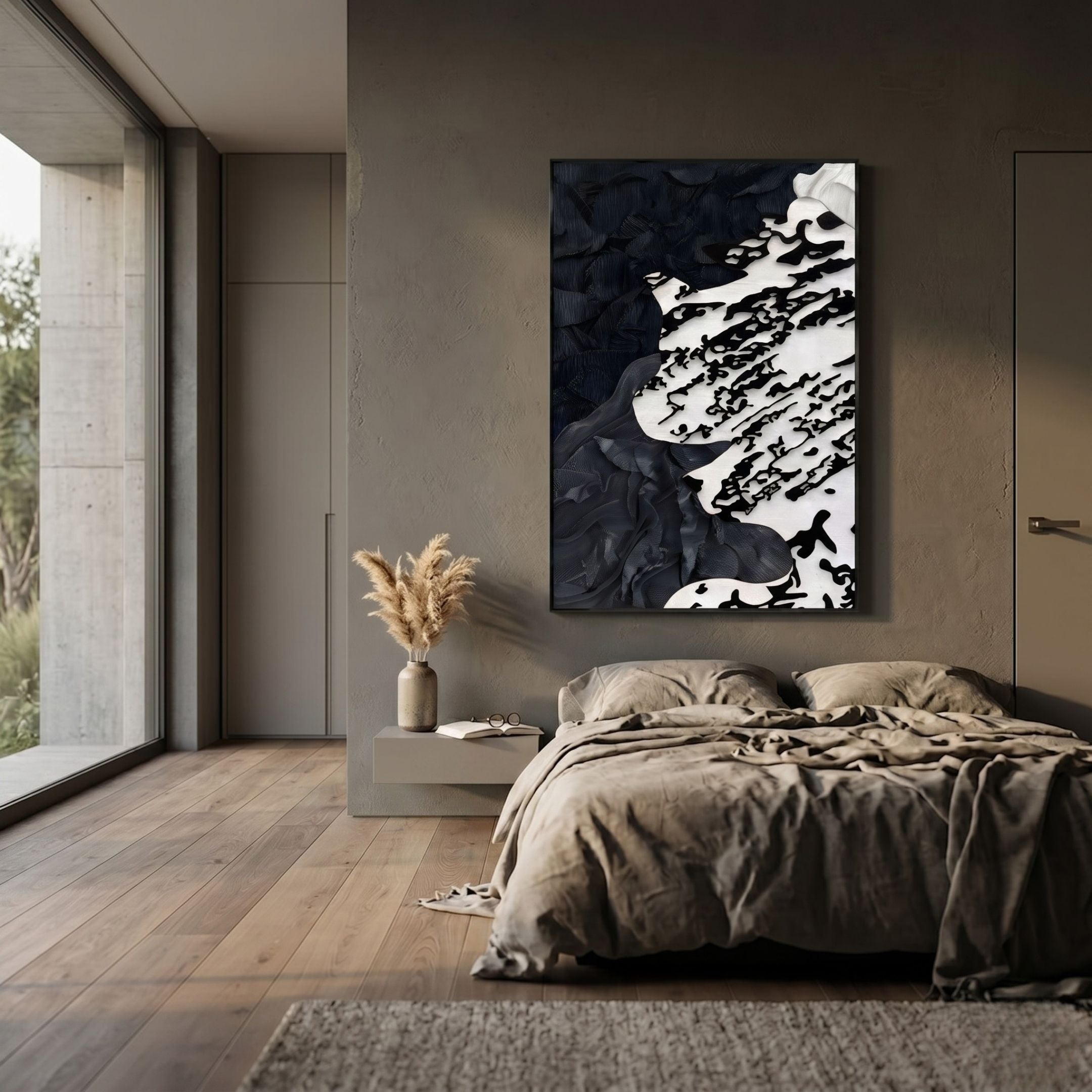 A modern, minimalist bedroom features a low bed, neutral bedding, and the Nivoria III Black & White Textured Abstract 3D Wall Art by Giant Sculptures above the headboard. Large windows fill the space with light, and a vase with dried grasses sits on a floating nightstand.