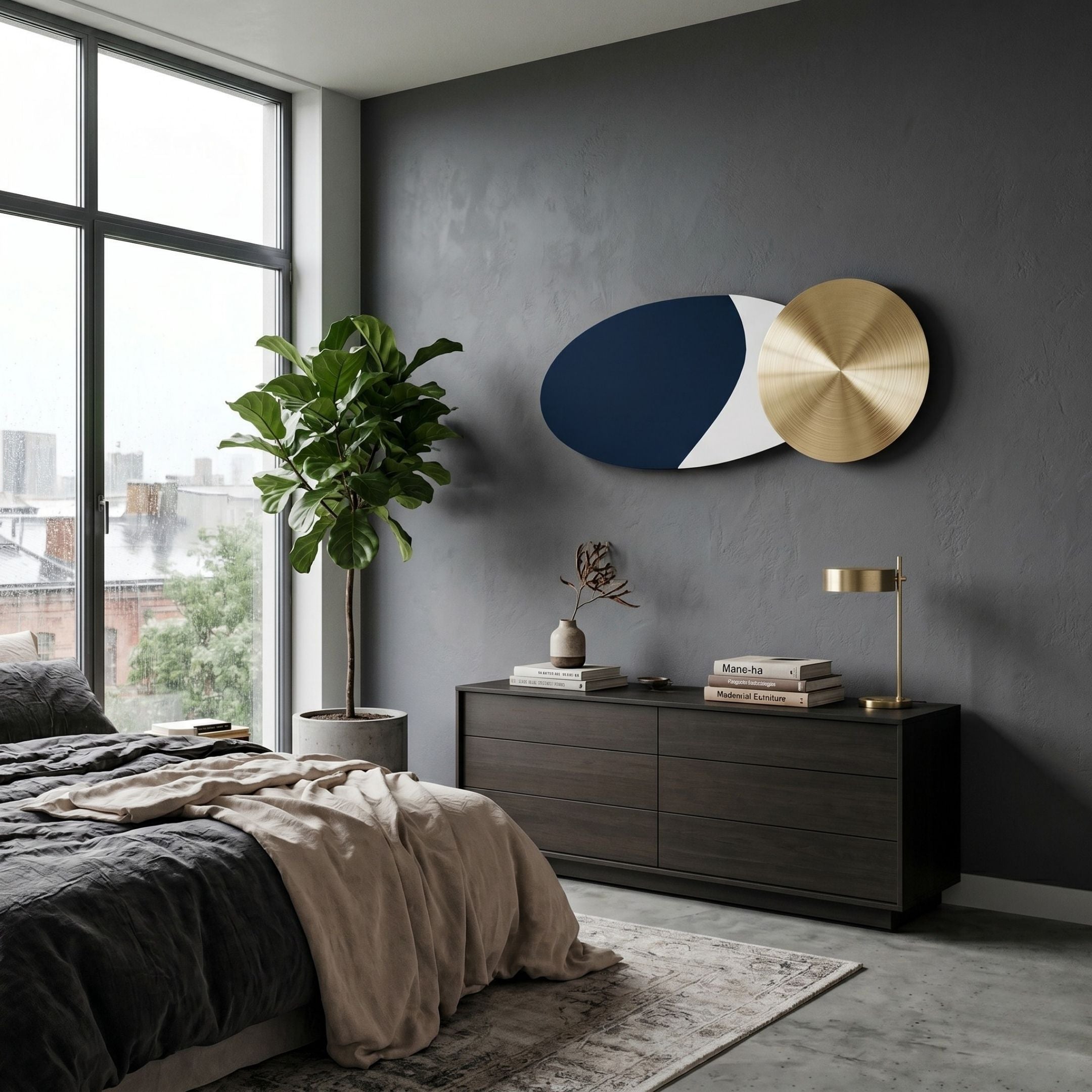 A modern bedroom with a gray accent wall, contemporary style, neutral bedding, a large potted plant, a wooden dresser with books and decor, a gold desk lamp, large windows, and the Aurelune Navy & White Gold Metal Disc 3D Wall Art by Giant Sculptures.