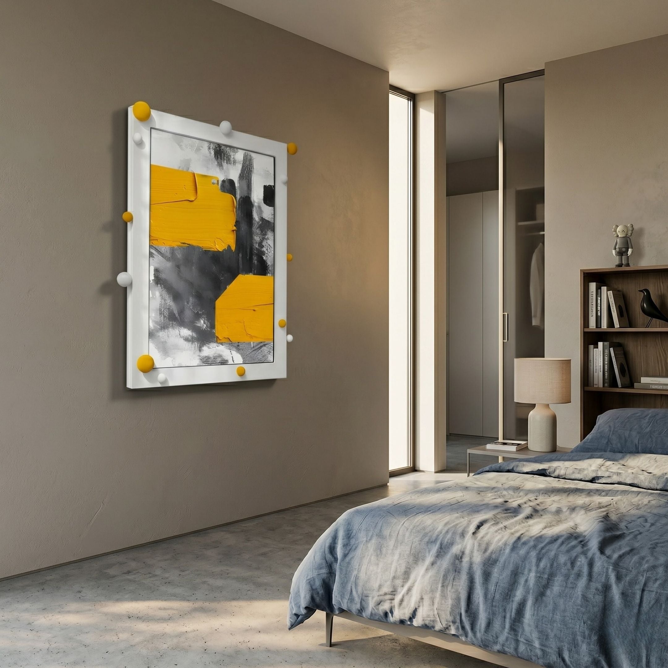 A modern bedroom with a gray bed and lamp features Vivexa Yellow & Grey Stroke Abstract 3D Wall Art by Giant Sculptures in a white frame. Sunlight from a tall window highlights the bookshelf and closet in this stylish, tranquil space.