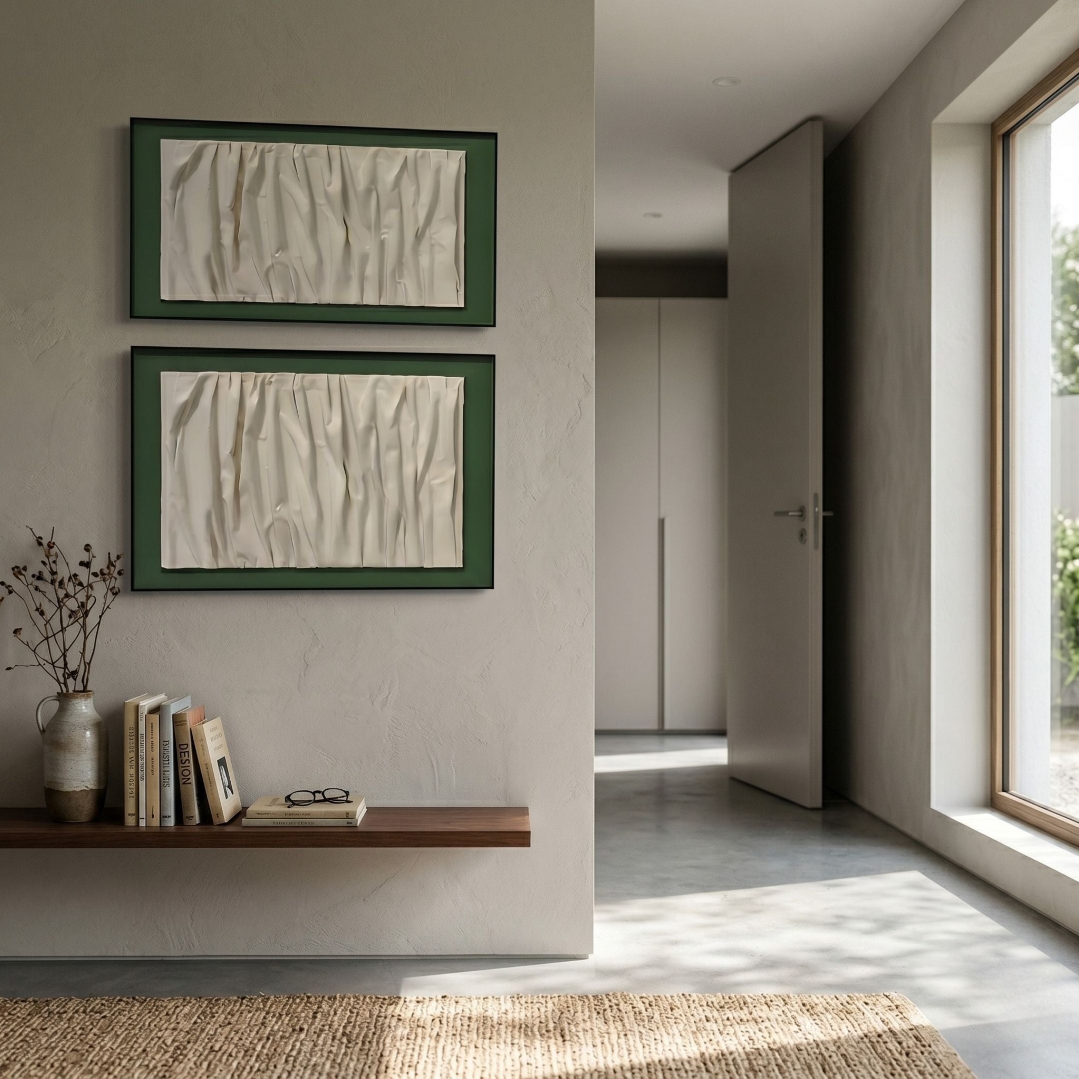 A minimalist room with beige walls, a large window, a wooden floating shelf with books and dried flowers, and Giant Sculptures’ Foldara Cream & Green Draped Paper Dual-Panel 3D Wall Art above the shelf. An open door leads to another room.