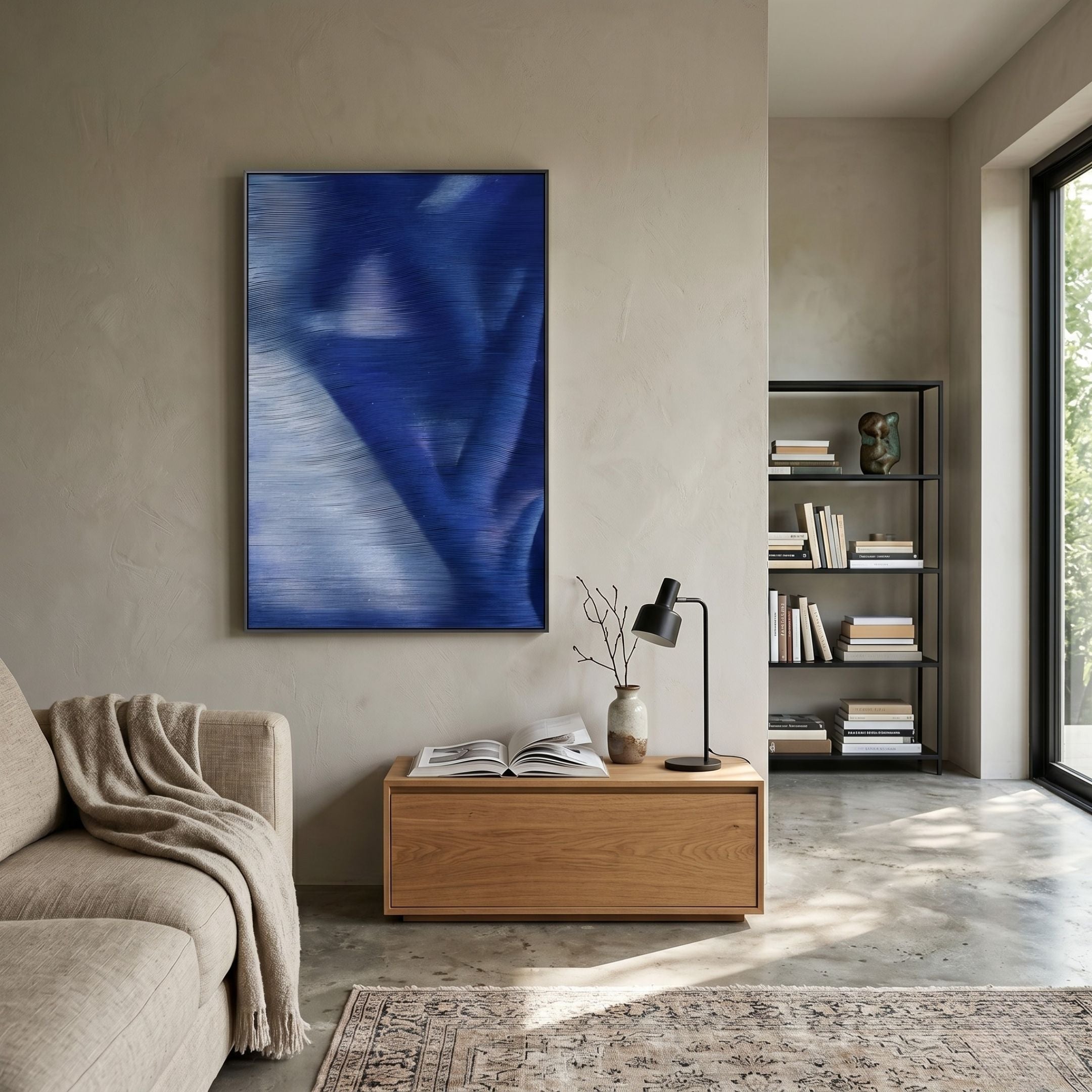 Rivara Cobalt Flow Hand-Painted Rope 3D Wall Art in cobalt blue and white displayed above a wooden console in a neutral-toned living room with bookshelf.