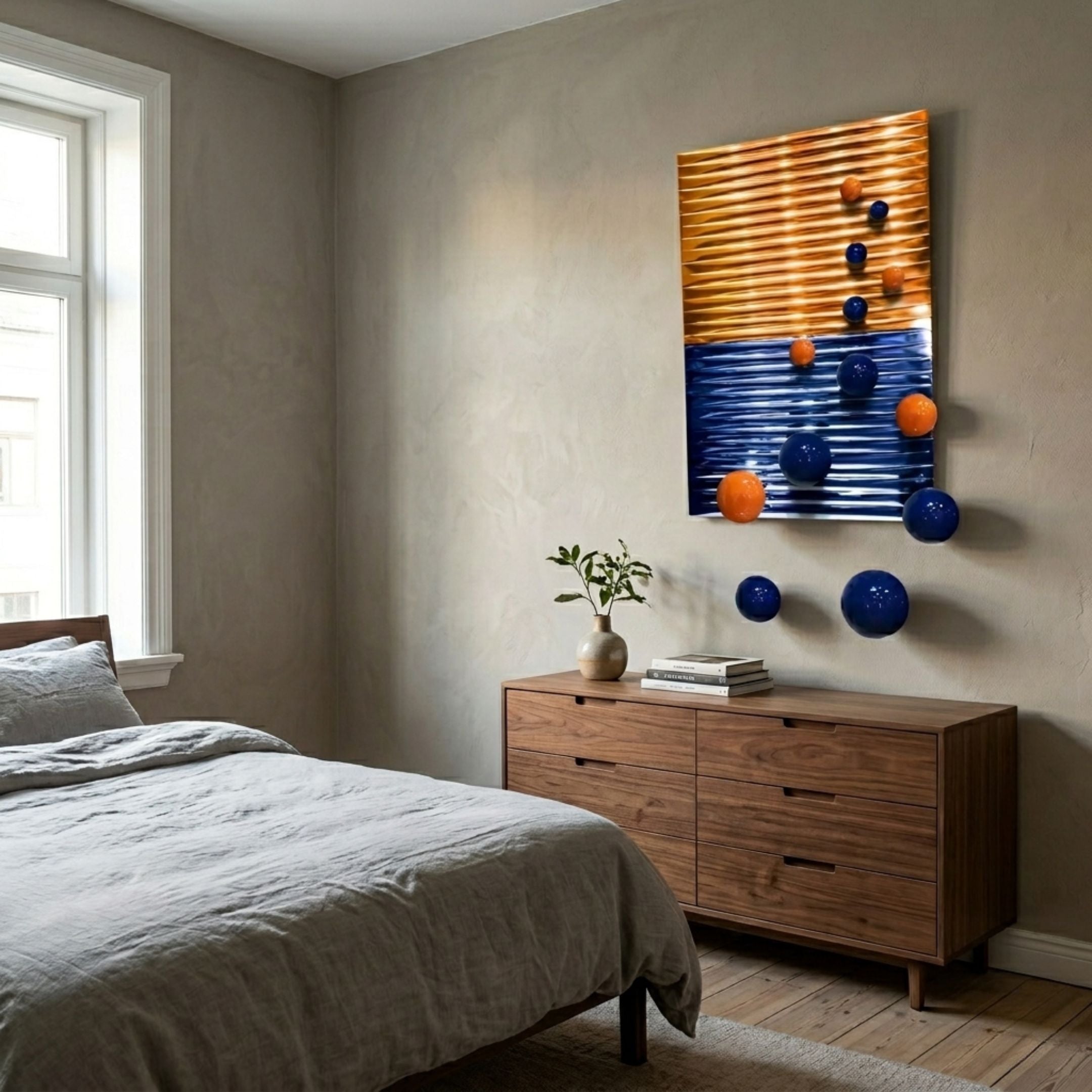 Orbentra Dual-Tone 3D Wall Art by Giant Sculptures mounted above a wooden dresser in a neutral bedroom, with blue and orange spheres trailing down the wall.