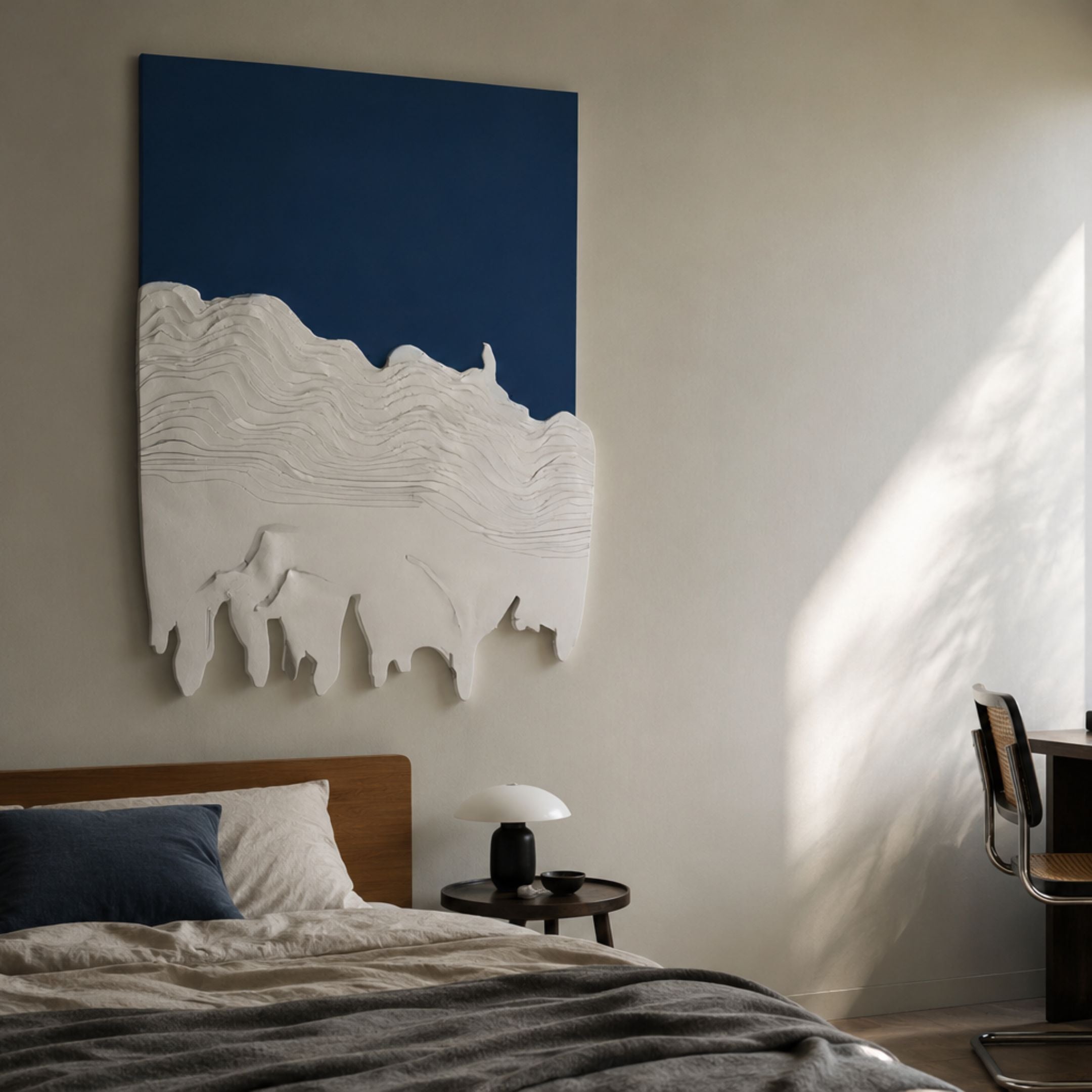Riftline Peakcut Blue Wood Carving 3D Wall Art by Giant Sculptures displayed above a wooden bed with linen bedding, side table lamp, and cane chair.