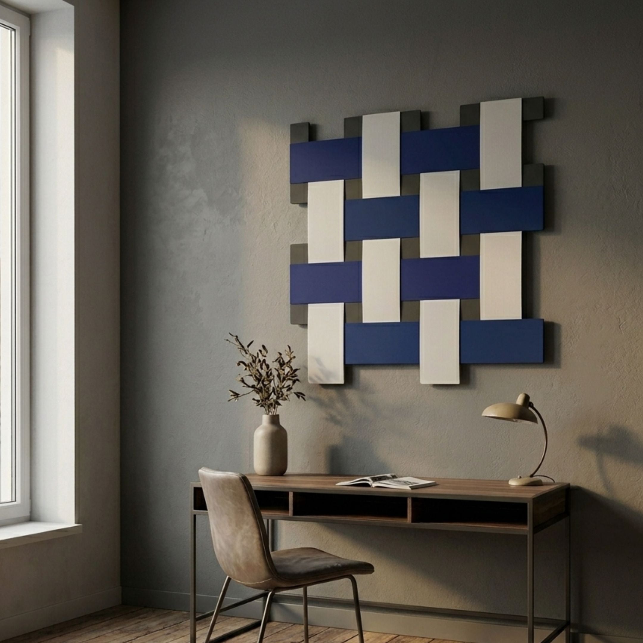 Tressel Interlock Blue Oil Painting 3D Wall Art by Giant Sculptures, with woven navy, white, and grey rectangles displayed above a wooden desk and chair.