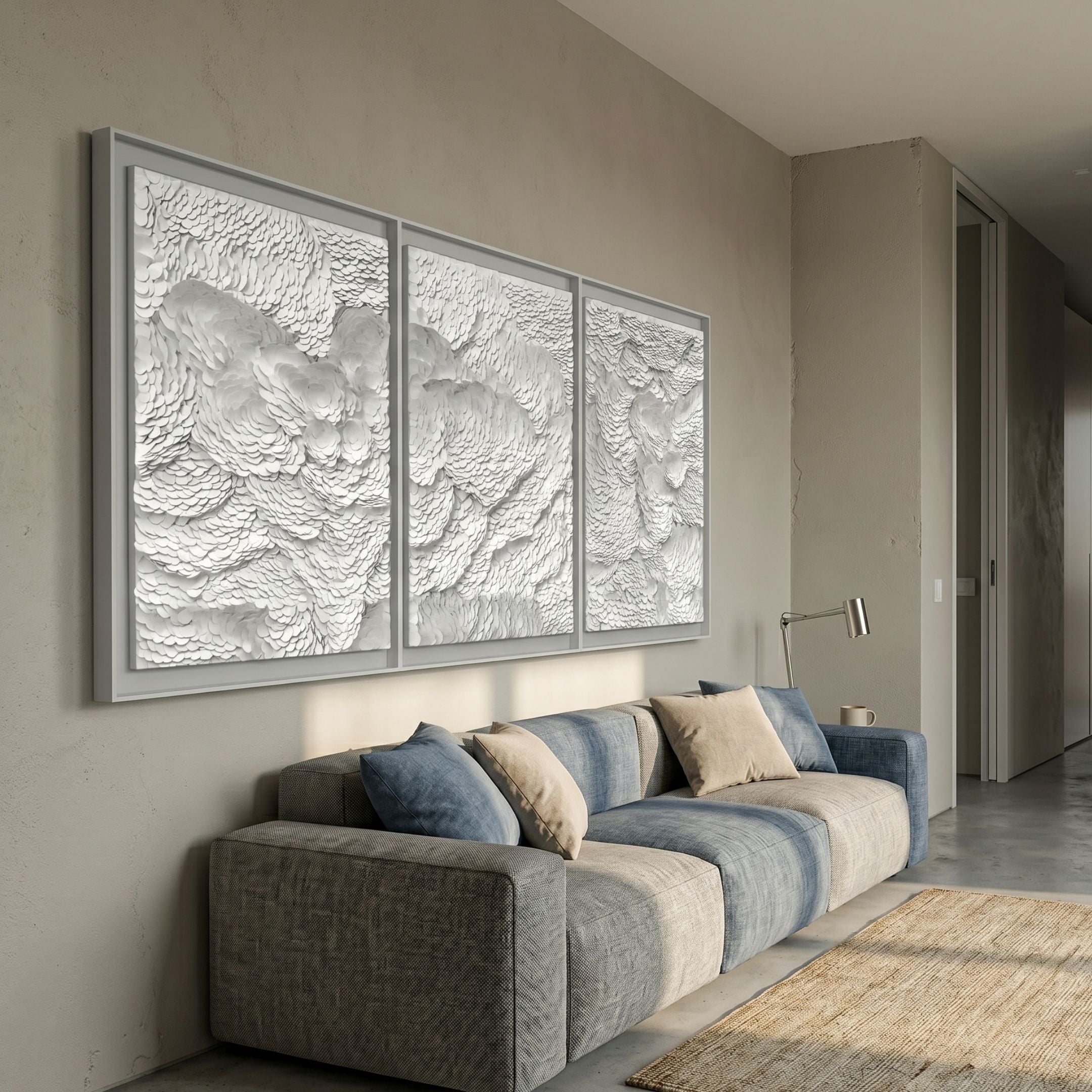 Nuvira White Triptych Swirl Leather 3D Wall Art by Giant Sculptures mounted above a blue and grey sofa in a modern living room with beige walls.