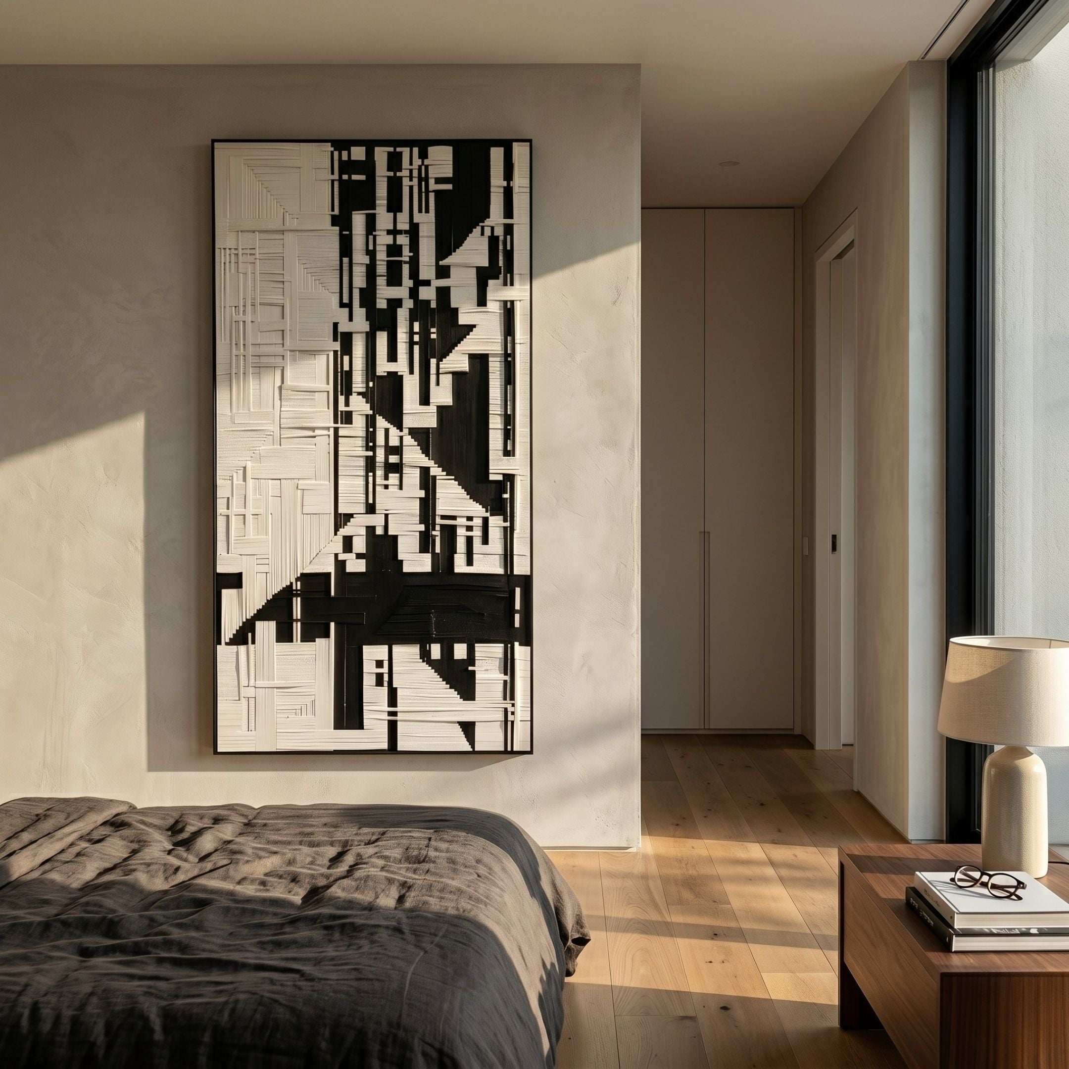 Lintrix Tall Black & White Geometric Woollen Knit 3D Wall Art mounted on a cream bedroom wall above a linen-dressed bed beside a hallway and nightstand.