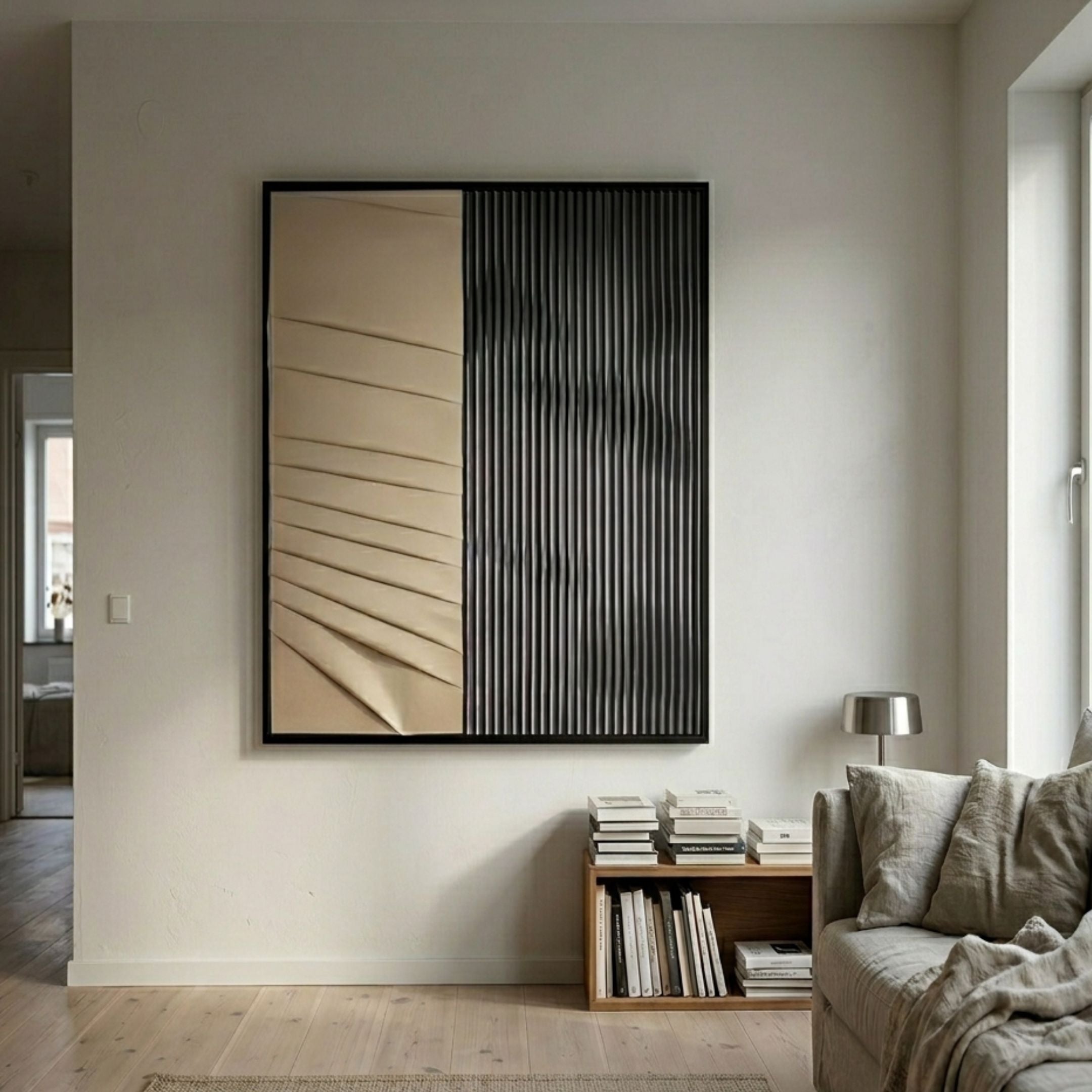 Ridge Beige & Black Leather & Acrylic 3D Wall Art with diagonal leather folds and vertical black blades, displayed above a low bookshelf in a neutral living room.