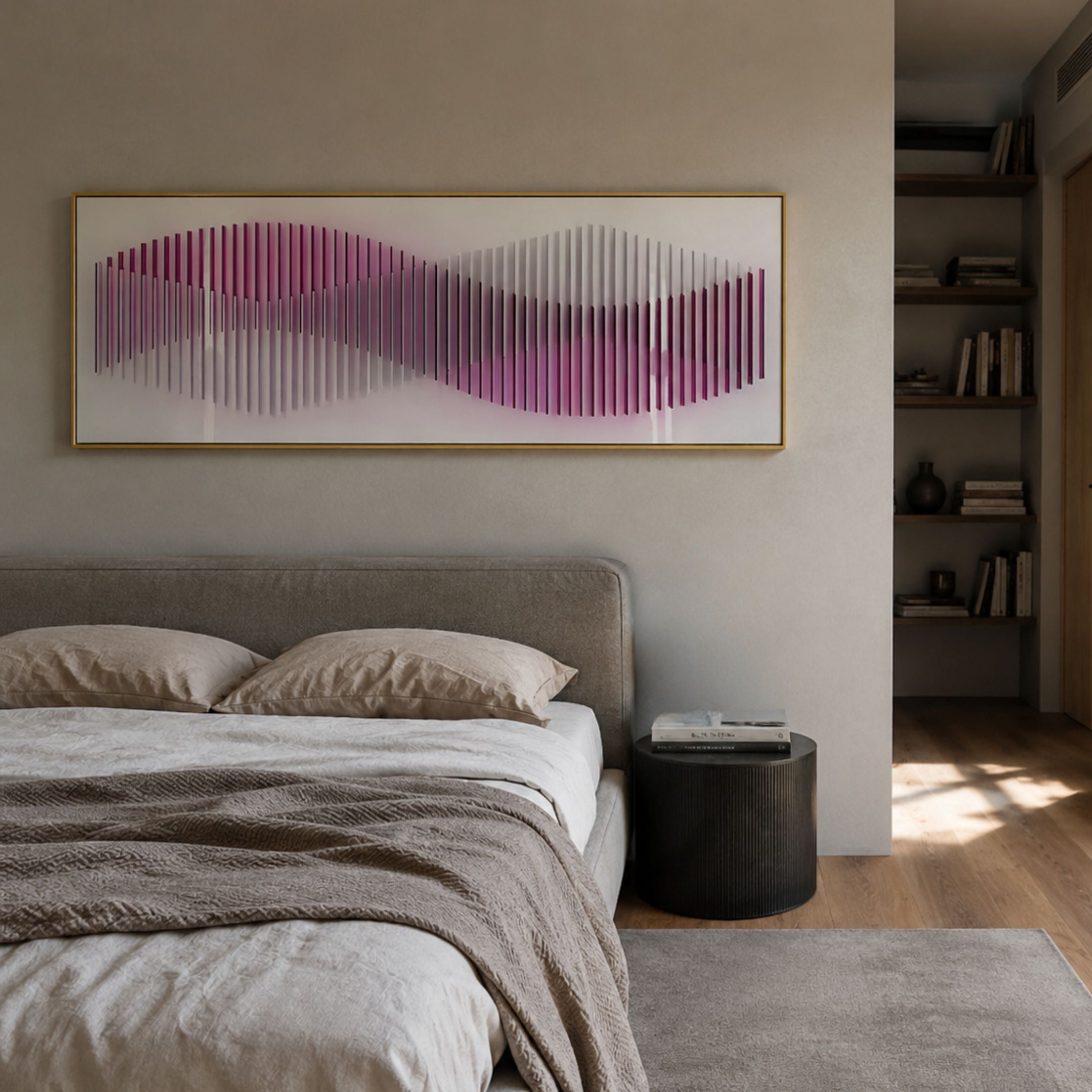 Harmoni Pink Gradient Wave Acrylic 3D Wall Art in a gold frame above an upholstered bed with linen bedding, beside a ribbed black side table.
