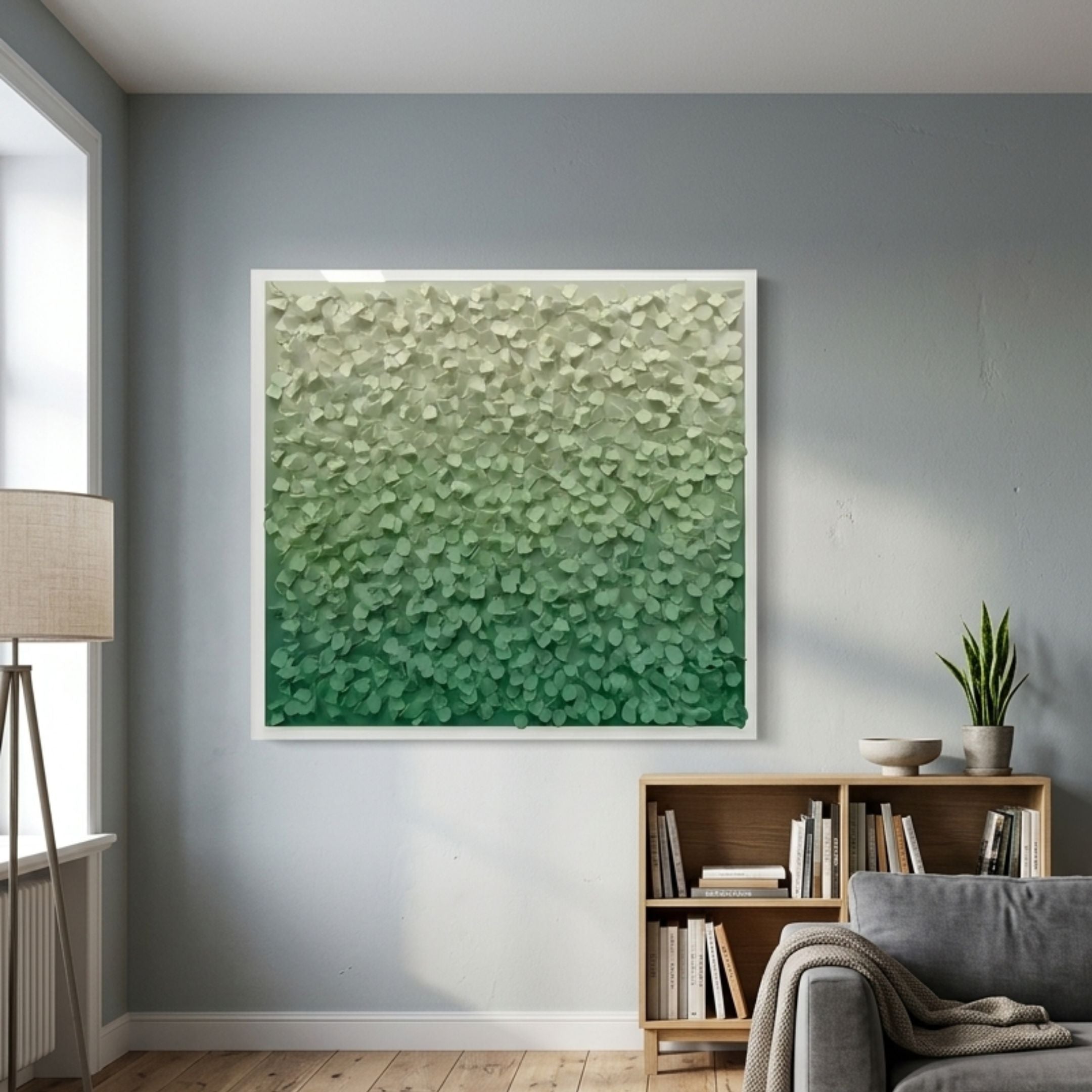 Bloom Mint & Emerald Green Curved Petal Acrylic 3D Wall Art in a white frame, displayed above an oak bookshelf in a grey-walled living room with floor lamp.