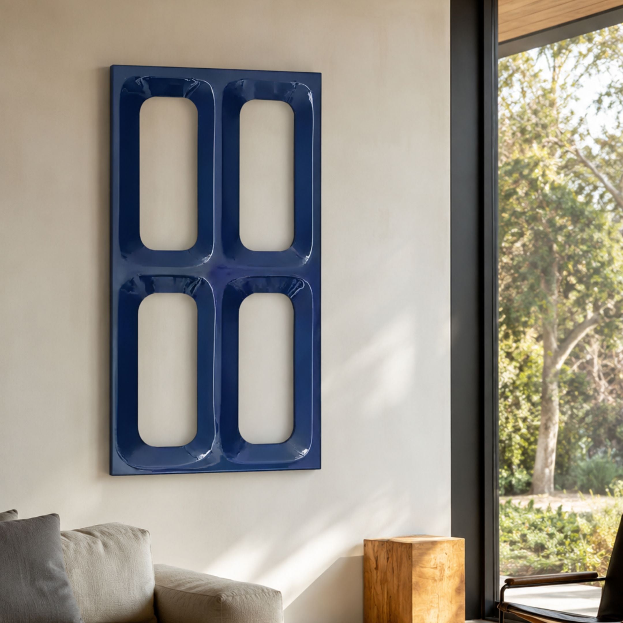 Lineris Blue Glossy Wood Relief 3D Wall Art with four recessed rounded rectangles, mounted on a cream wall in a living room beside a large window.