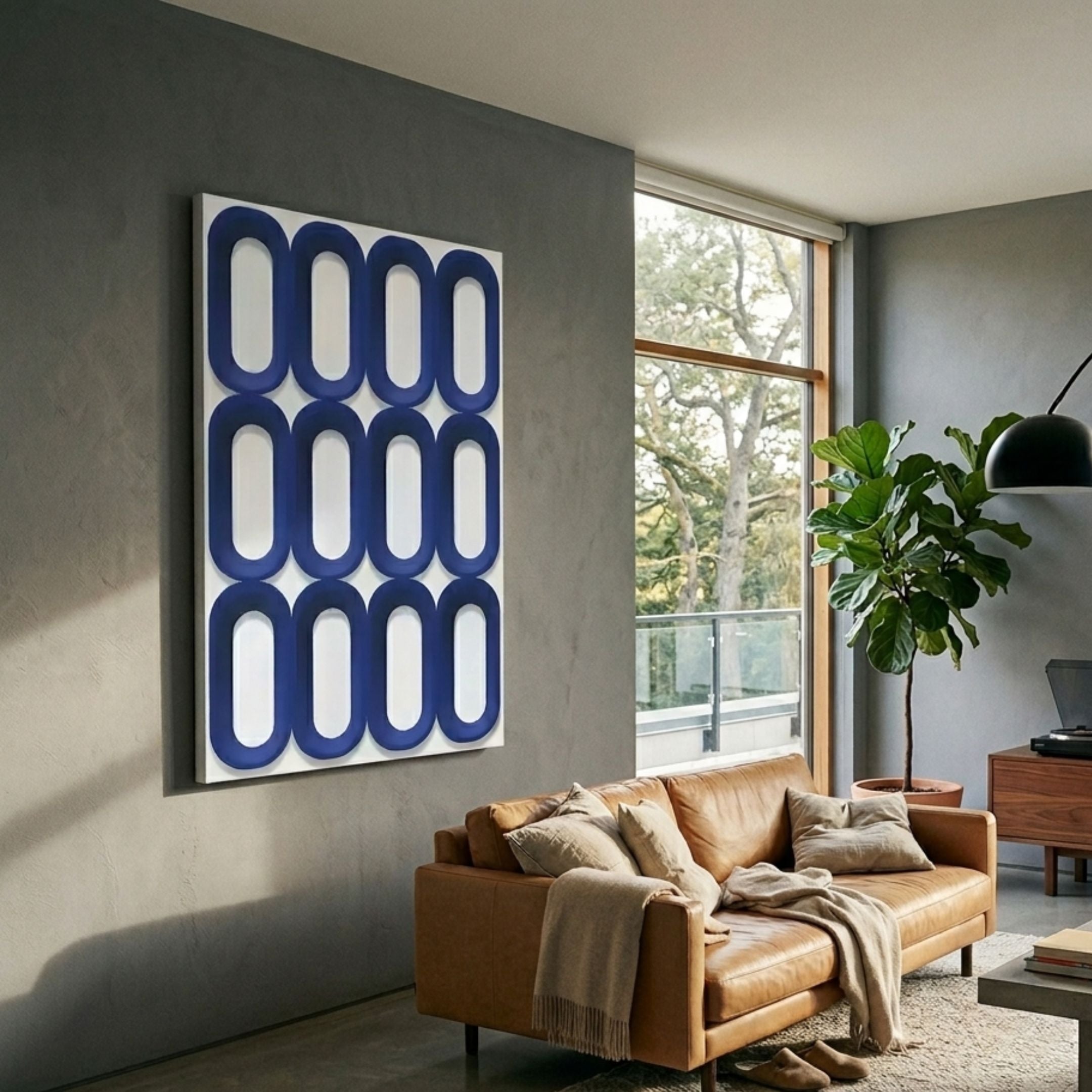 Revela White & Blue Geometric Wood Relief 3D Wall Art by Giant Sculptures displayed in a modern living room above a tan leather sofa beside a tall window.