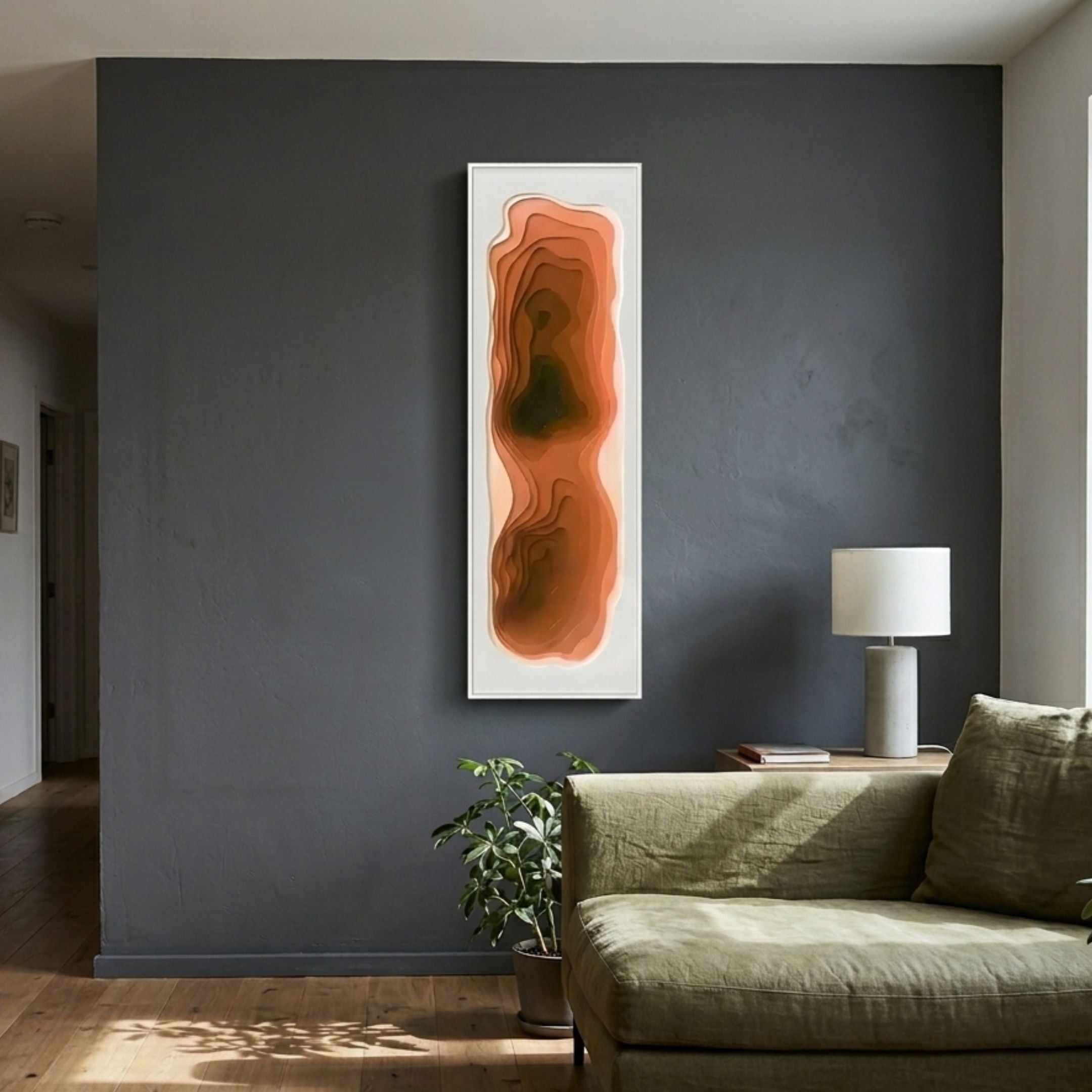 Bathys Orange Gradient Carved 3D Wall Art mounted vertically on a dark grey wall above a green linen sofa, plant, and table lamp in a modern living room.