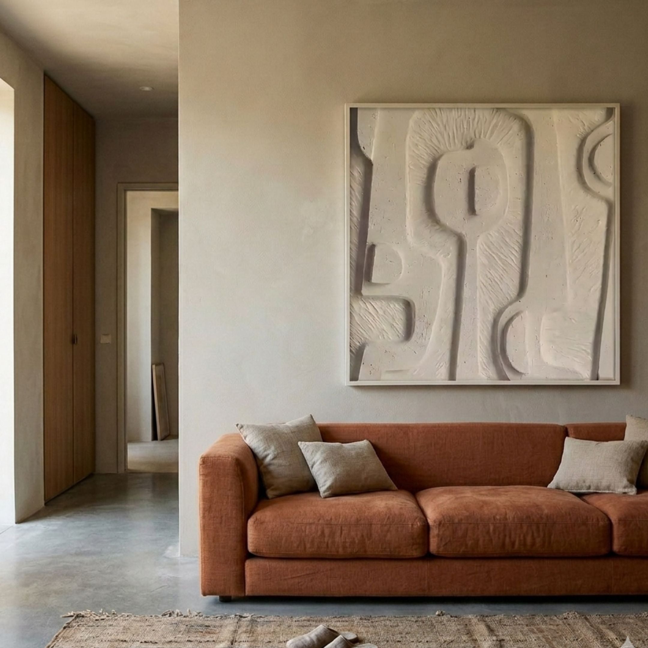 Terravura Square Sandstone I 3D Wood Relief Wall Art by Giant Sculptures displayed above a terracotta linen sofa in a warm beige Wabi-Sabi living room.
