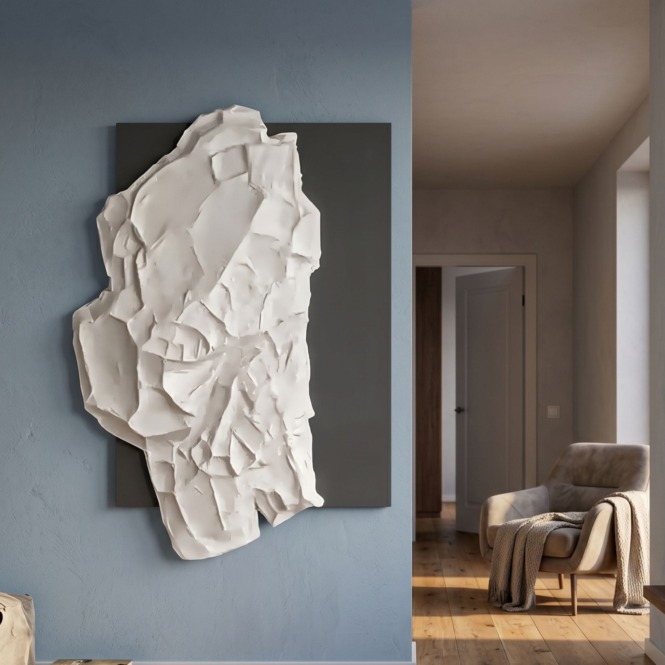Veritas White & Silver Abstract Wood Relief 3D Wall Art by Giant Sculptures mounted on a blue-grey wall beside a hallway with a beige armchair and throw.