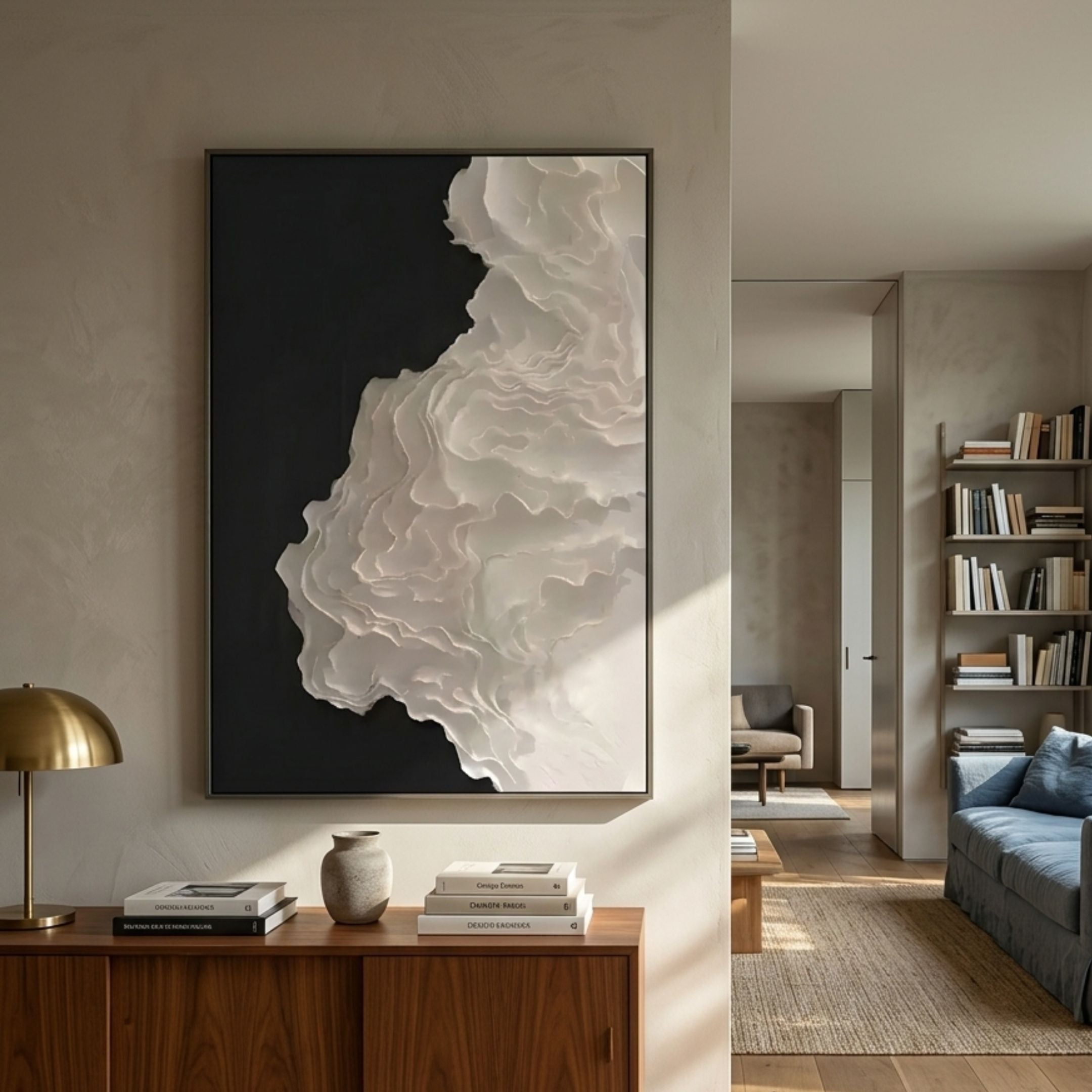 Stratura V Black & White Layered Paper Canvas Wall Art by Giant Sculptures mounted above a walnut sideboard in a sunlit living room with brass lamp.