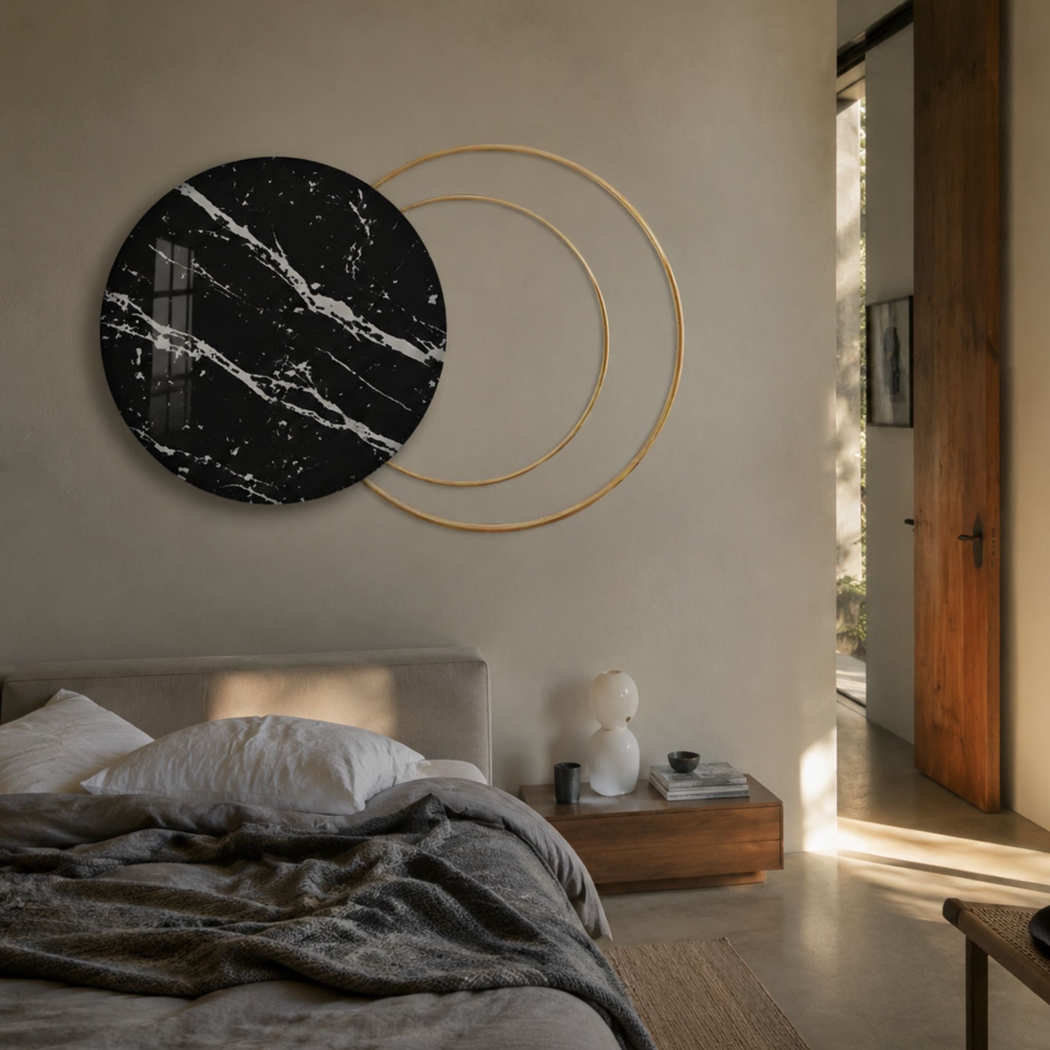 Eclipse Luxe Black Noir Marble Circular Ring Wall Art by Giant Sculptures mounted above a bed, pairing a veined black marble disc with two gold rings.