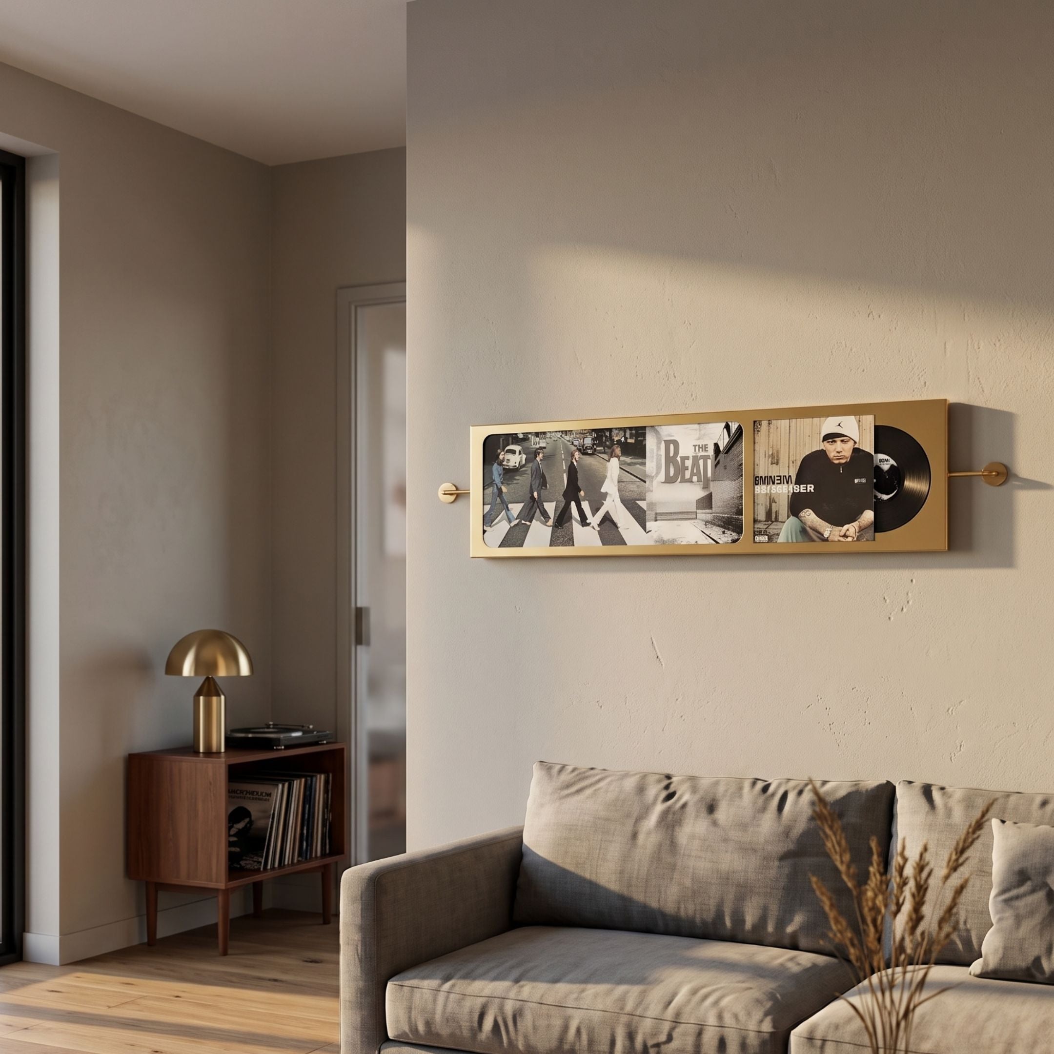 Resonance Record Wall Art by Giant Sculptures mounted above a grey sofa, featuring Beatles Abbey Road and Eminem covers in a gold mixed-media panel.