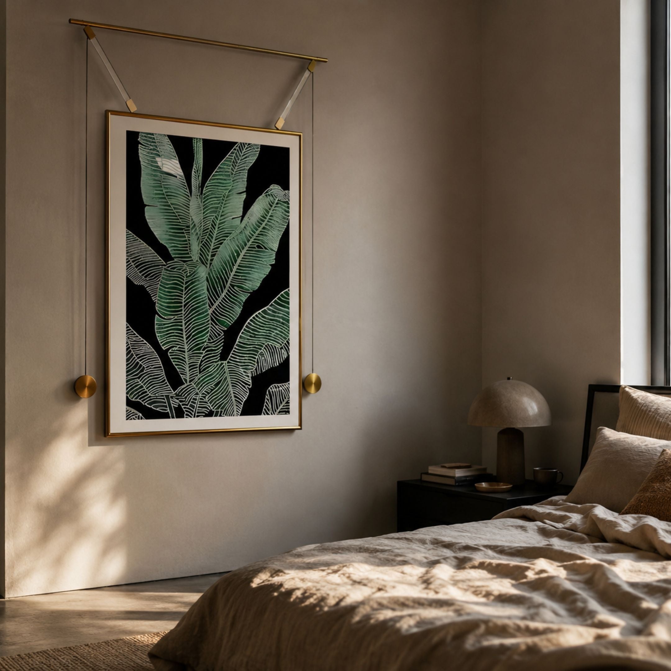 Glacia Green Botanical Crystal Hanging Framed Wall Art by Giant Sculptures, green banana leaves on black suspended from a gold rod, above a bedroom nightstand.