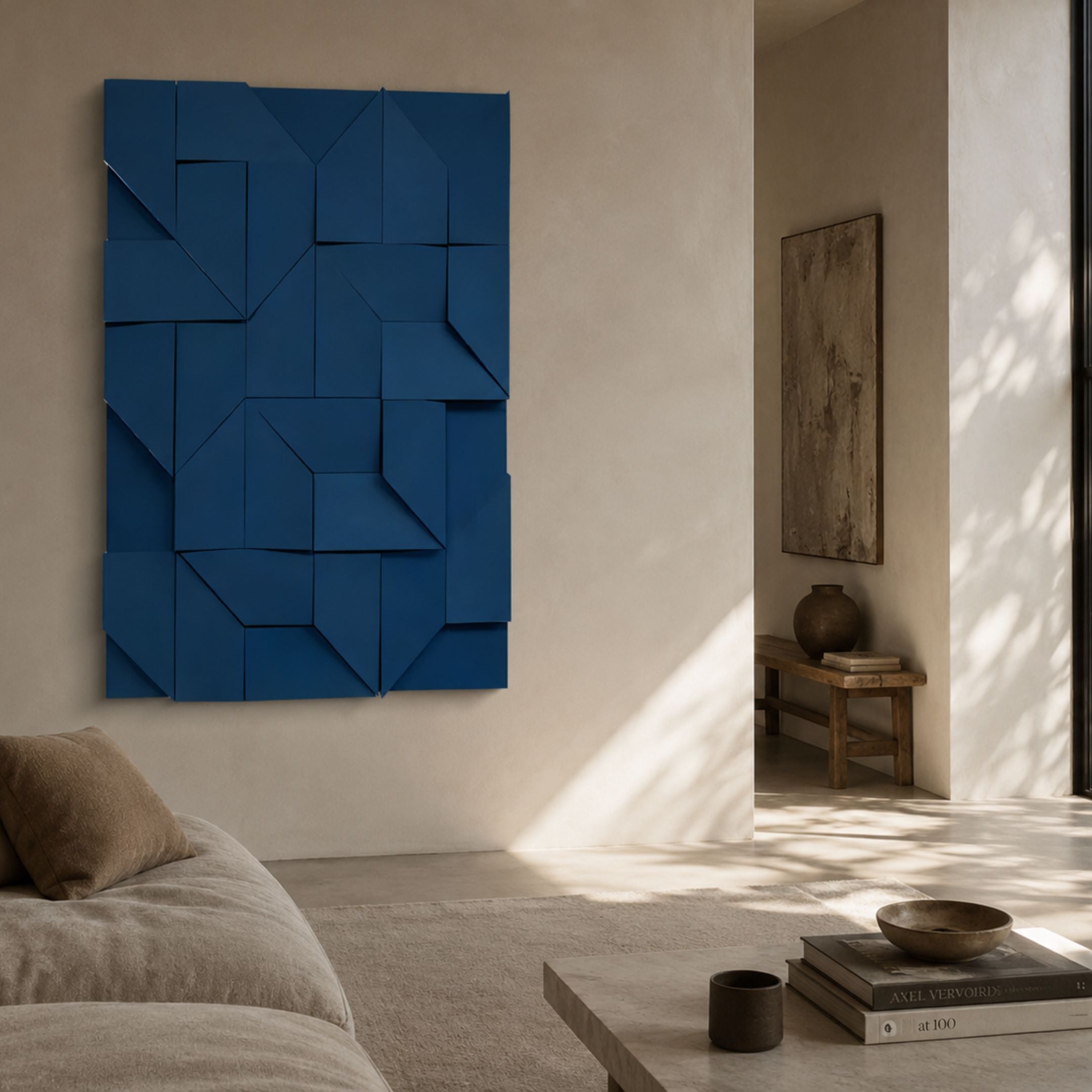 Prisma Blue Geometric Panel 3D Wall Art by Giant Sculptures mounted in a minimalist living room with a beige sofa, stone coffee table, and rustic console.