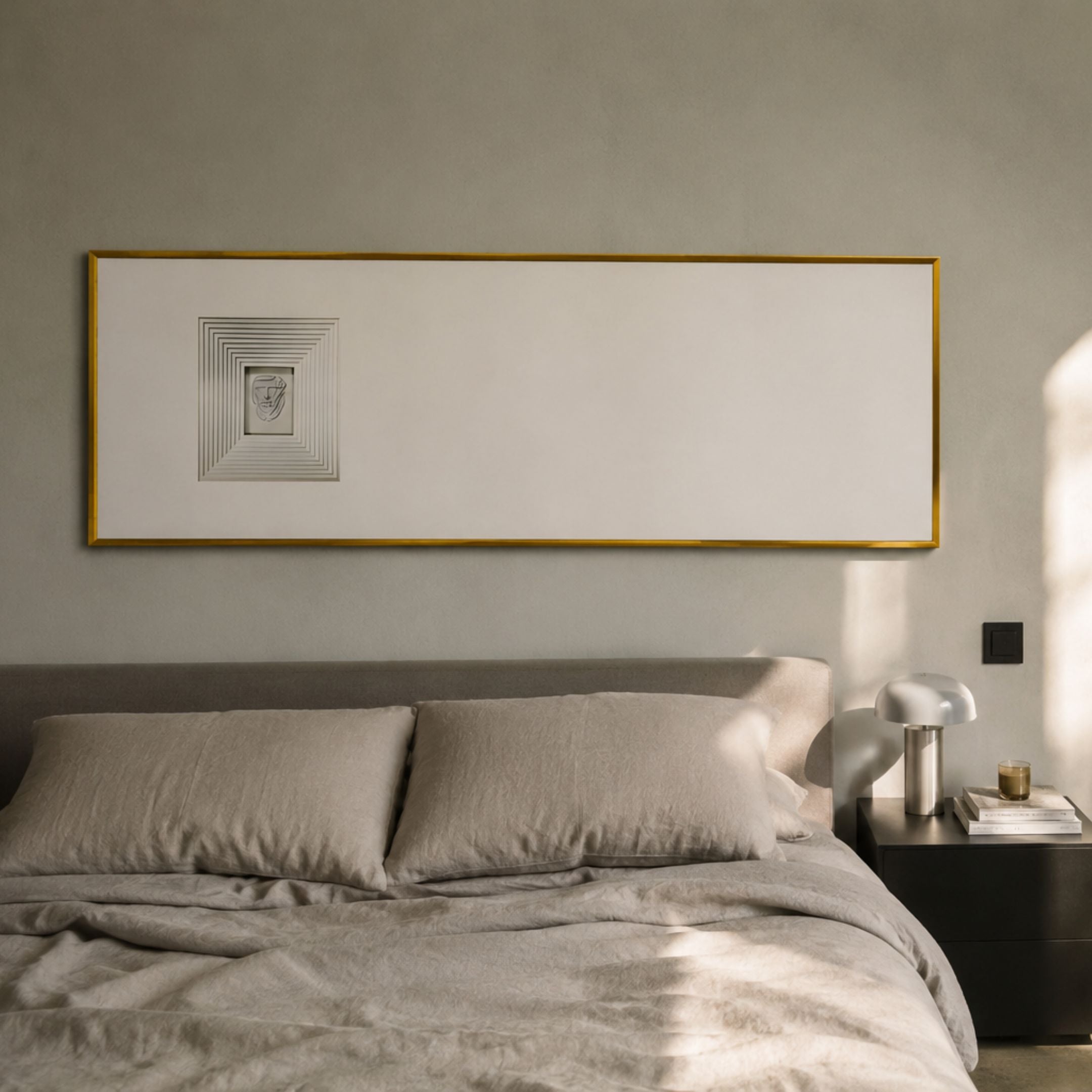 Lustreline White Left Plaster Statue Cardboard Wall Art by Giant Sculptures in a thin gold frame above a grey linen bed with bedside table and lamp.