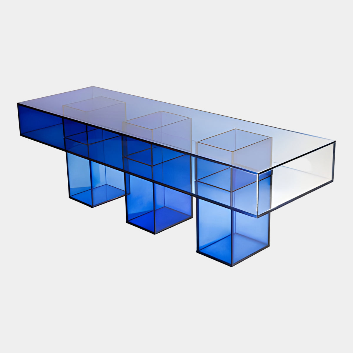 Blue Graded Box Acrylic Bench on Three Cubes - 140cm, a clear acrylic bench with three blue cube legs deepening in color toward the floor, shown on a plain white background.