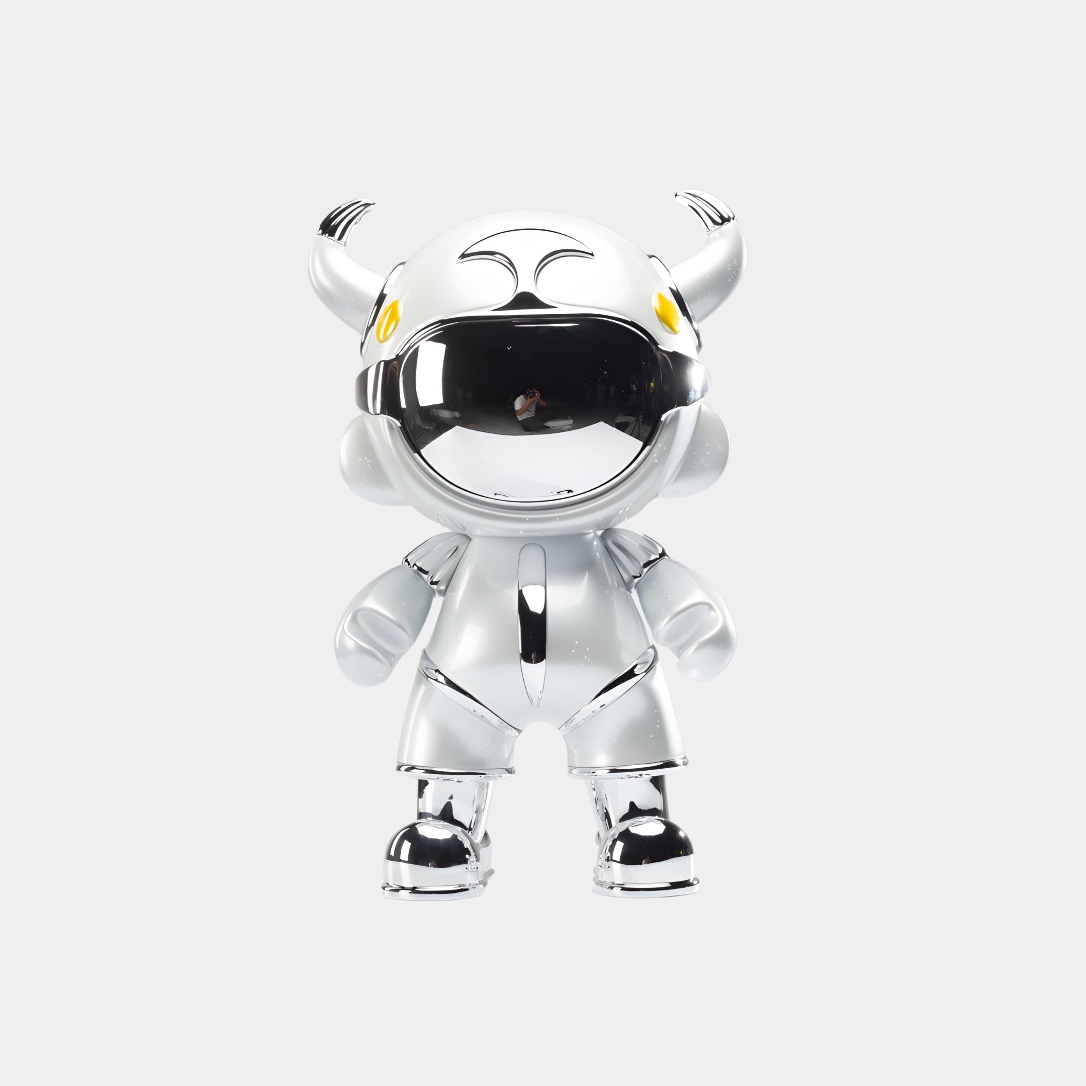 The Giant Sculptures Silver Suit Astro Devil Figure (48cm) features a horned helmet, yellow eyes, and a reflective visor—ideal as futuristic astronaut decor against a white background.