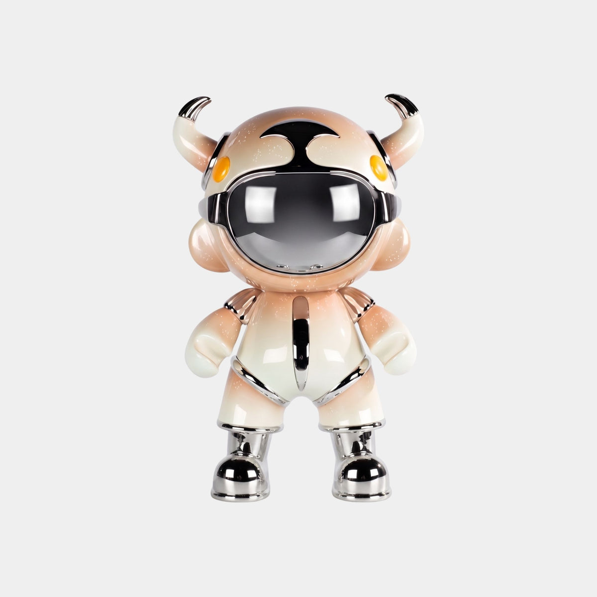 The Champagne Suit Astro Devil Figure (48cm) by Giant Sculptures features a metallic helmet, orange and white suit, small horns, round yellow eyes, and chrome accents on its feet, hands, and joints against a plain gray background.
