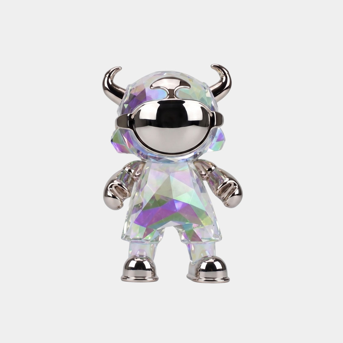 The Spectrum Prism Astro Devil Figure (21cm) by Giant Sculptures features a small, glossy, faceted body with iridescent rainbow colors, a mirrored helmet, silver horns, and metallic accents—a futuristic collectible sculpture.