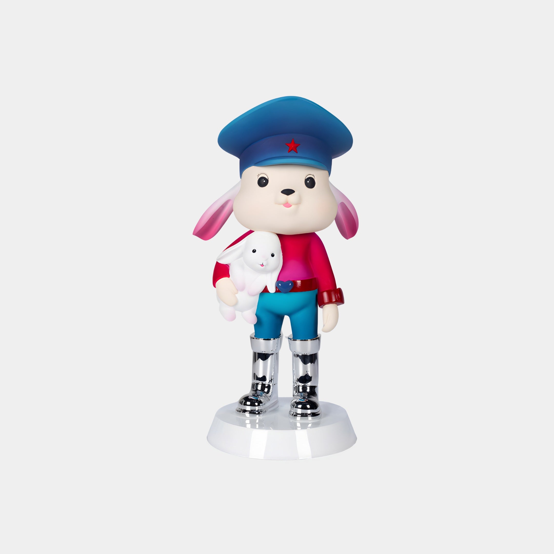 The Azure Star Bunny Guard Figure - 55cm by Giant Sculptures showcases a dog in a blue hat with a red star, pink shirt, blue shorts, and silver boots holding a white rabbit plush, standing on a white base—perfect for luxury home decor.
