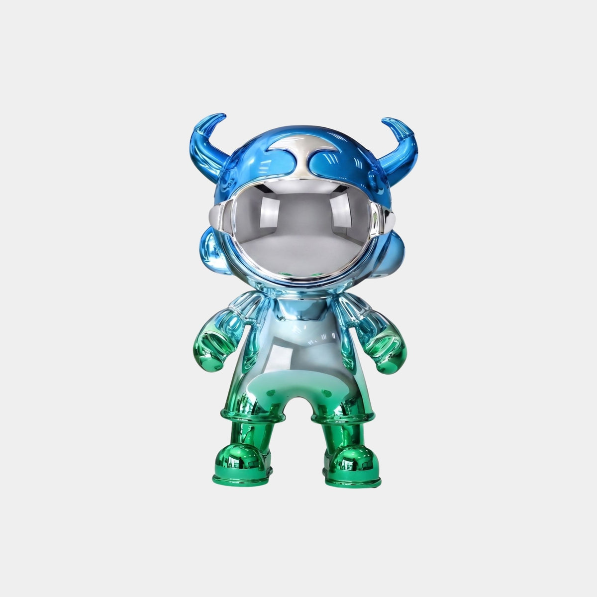 The Giant Sculptures Blue & Green Electroplated Astro Devil Figure (35cm) features blue horns, a helmet, green boots and gloves, and a reflective silver face that mirrors its surroundings.