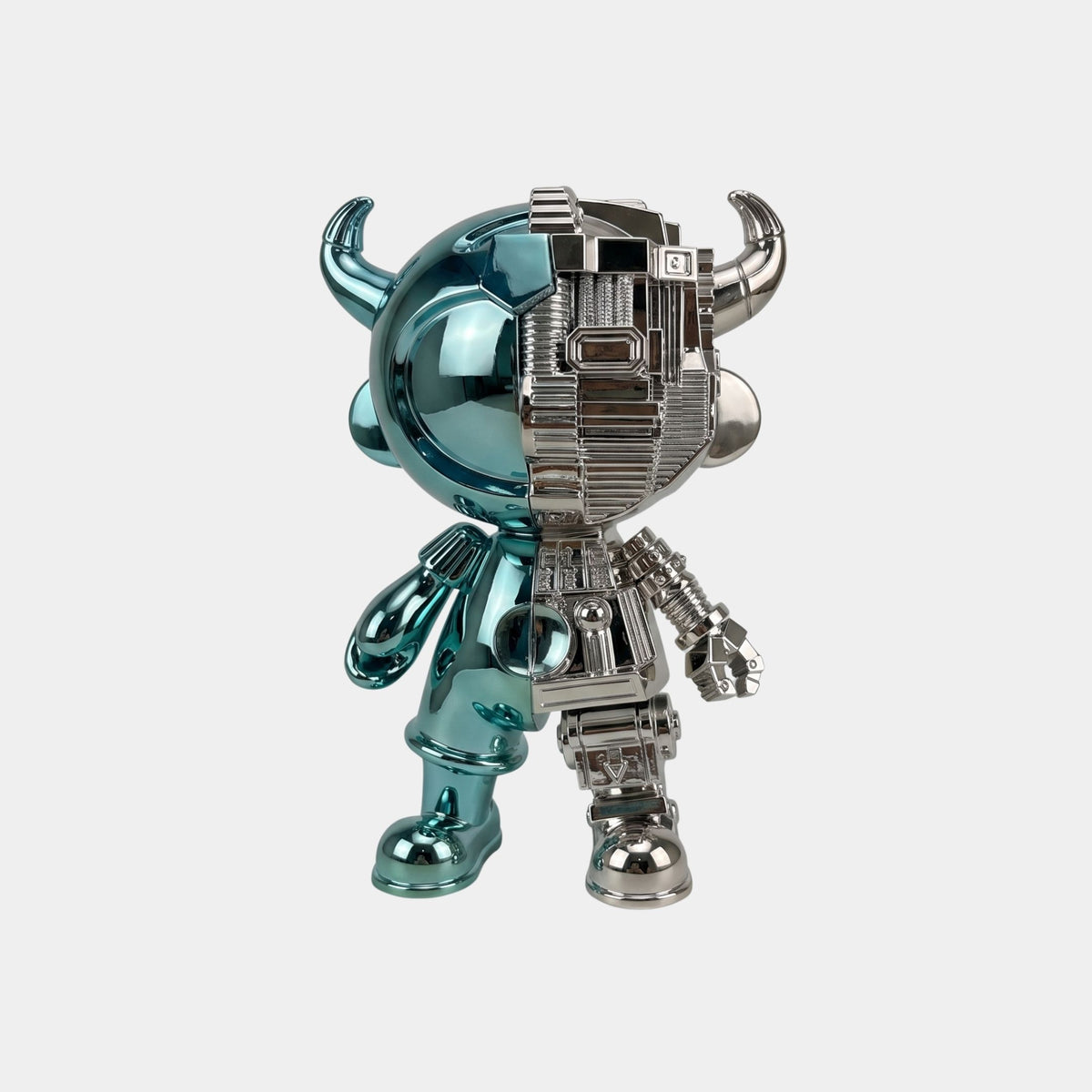 The Teal & Silver Split Astro Devil Figure - 35cm by Giant Sculptures features a shiny finish with one teal, smooth half and one silver, mechanical half with horns—a striking collectible sculpture for any display.
