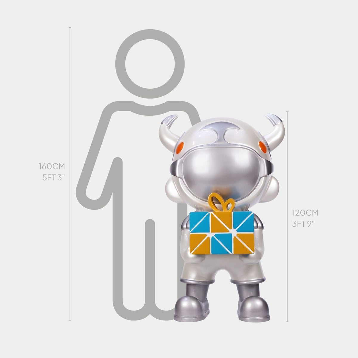 The Titan Silver Gift Box Astro Devil Sculpture by Giant Sculptures stands 120 cm tall, depicting a silver astronaut holding a colorful gift in front of a height chart beside a 160 cm person outline.