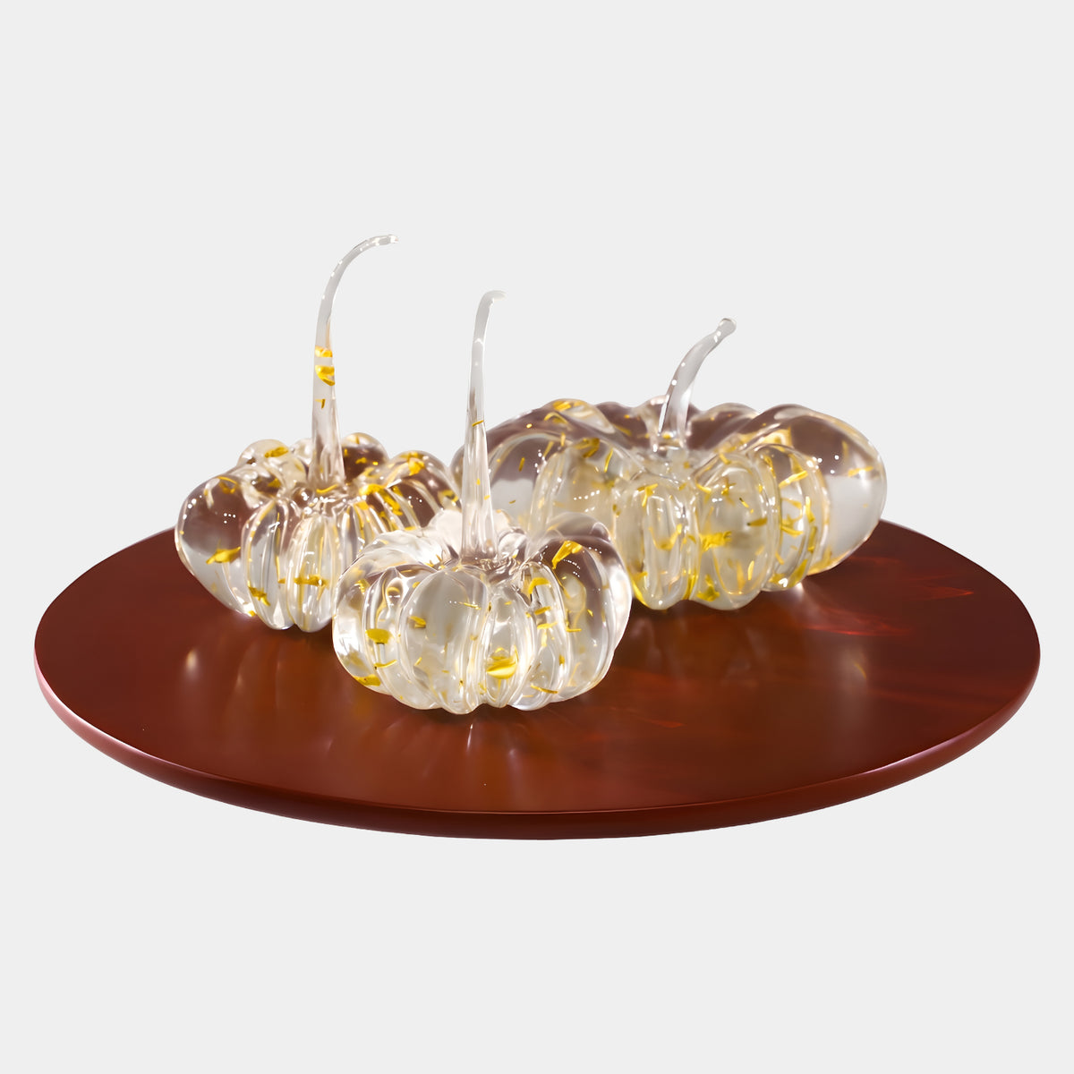 Clear Gold Leaf Pumpkin Trio on Red-Brown Disc Sculpture, 60cm, three ribbed resin pumpkins with gold flecks and curling stems on a glossy red-brown disc, plain light background.