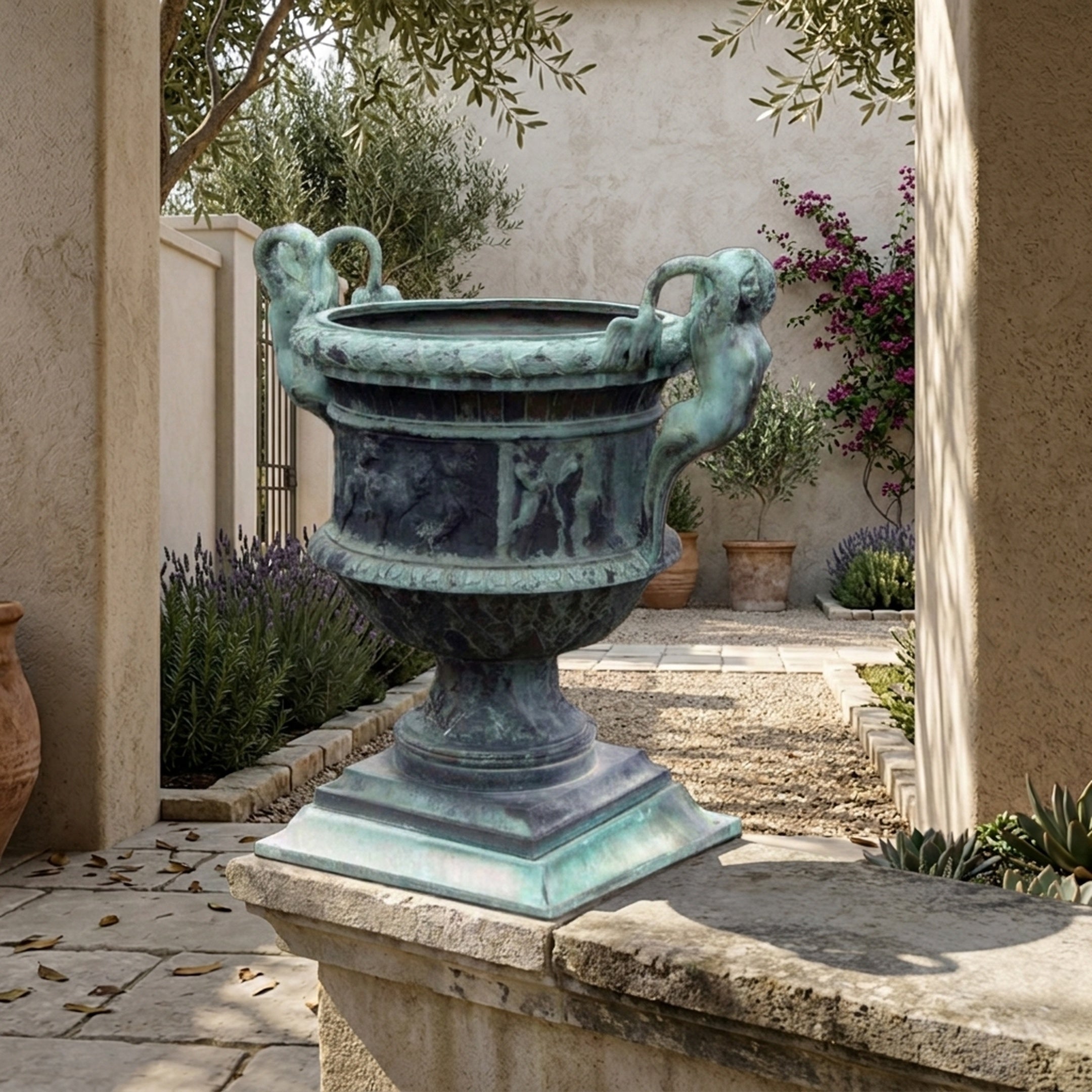 Classical Bronze Cherub Urn Planter Sculpture by Giant Sculptures with verdigris patina and putti handles, displayed on a stone plinth in a Mediterranean courtyard.
