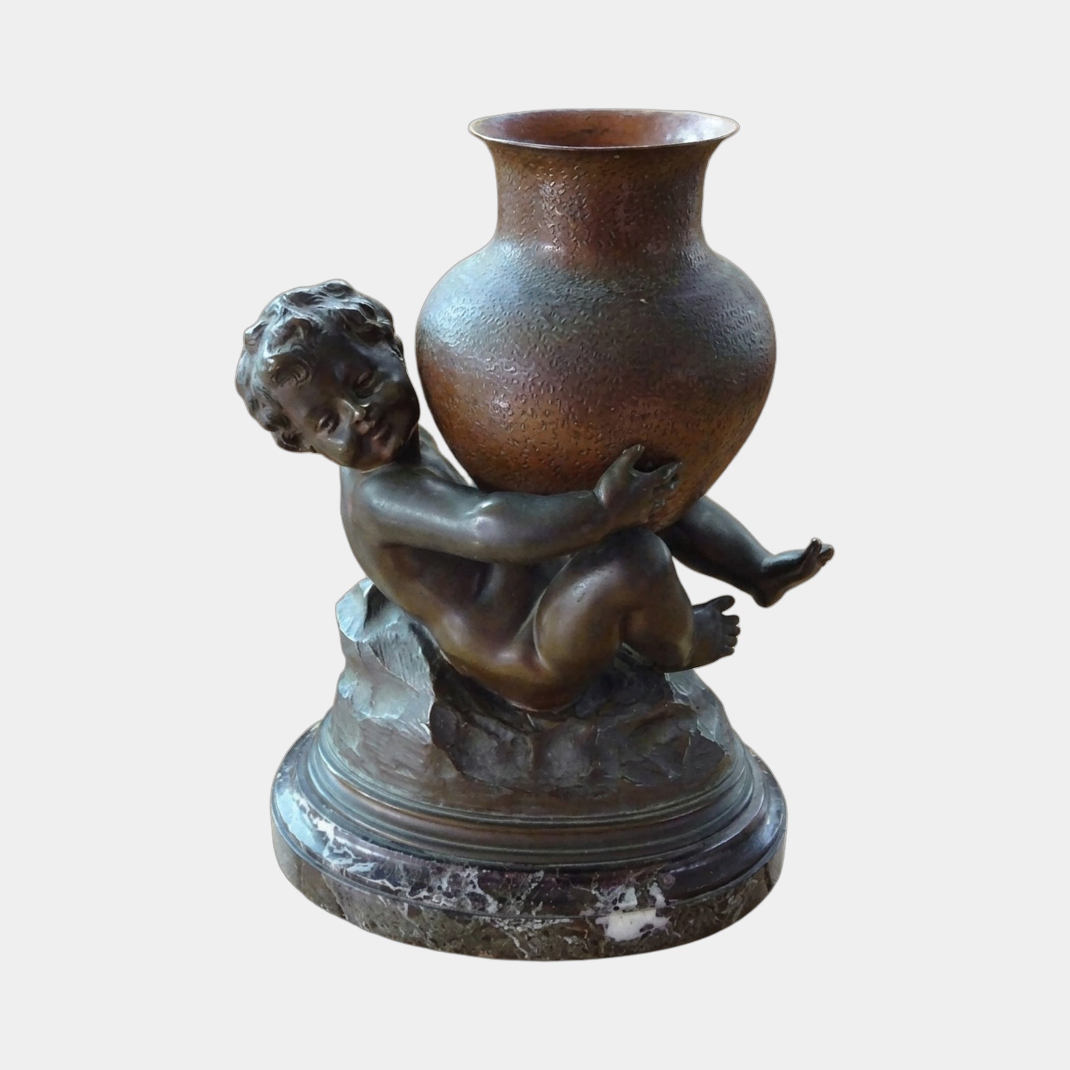Classical Cherub Child and Urn Bronze Sculpture by Giant Sculptures, showing the dark patina cherub crouched on a rocky base lifting a reddish-brown urn.